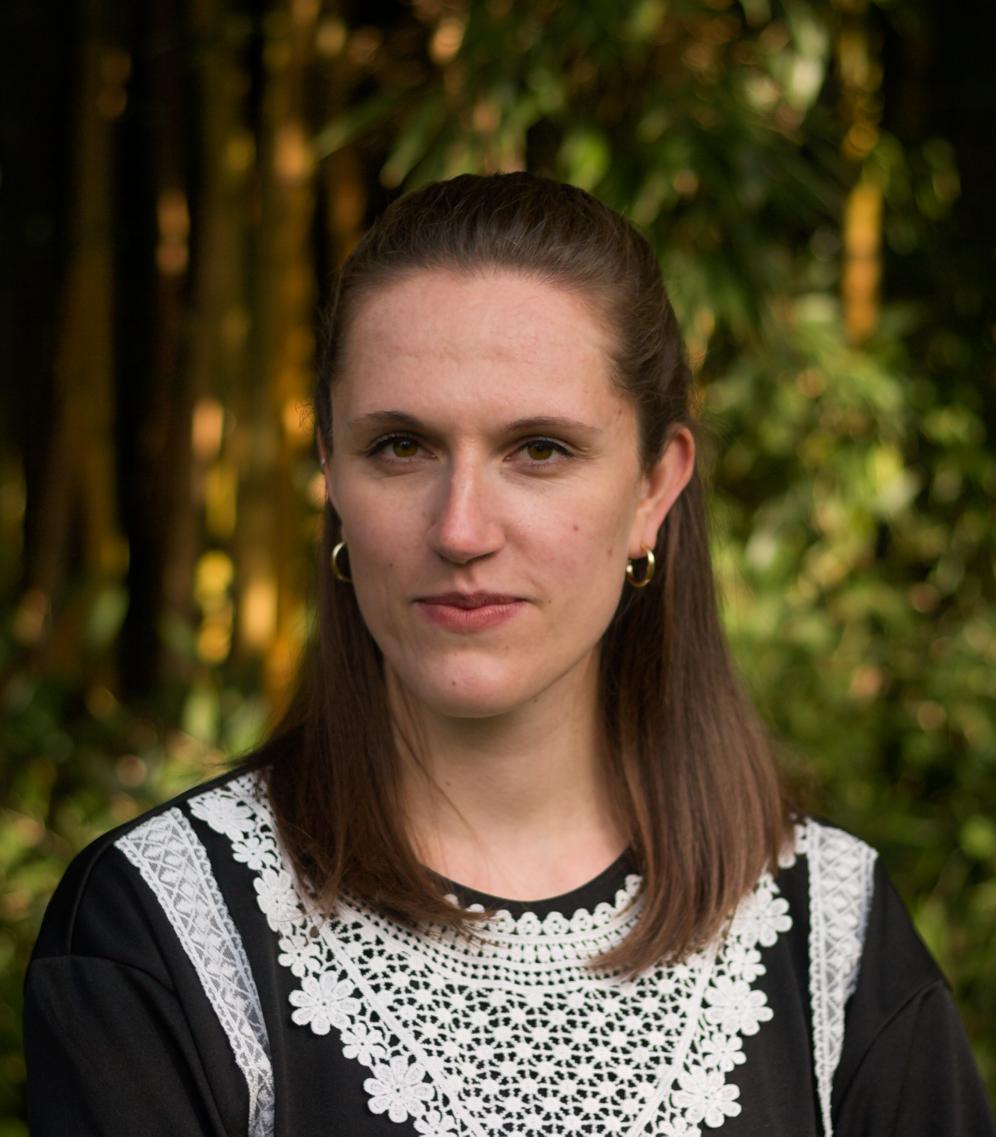 Carolin Senft, Assistenz Schauspiel, im Portrait vor grünem Hintergrund (Palmengarten Frankfurt).