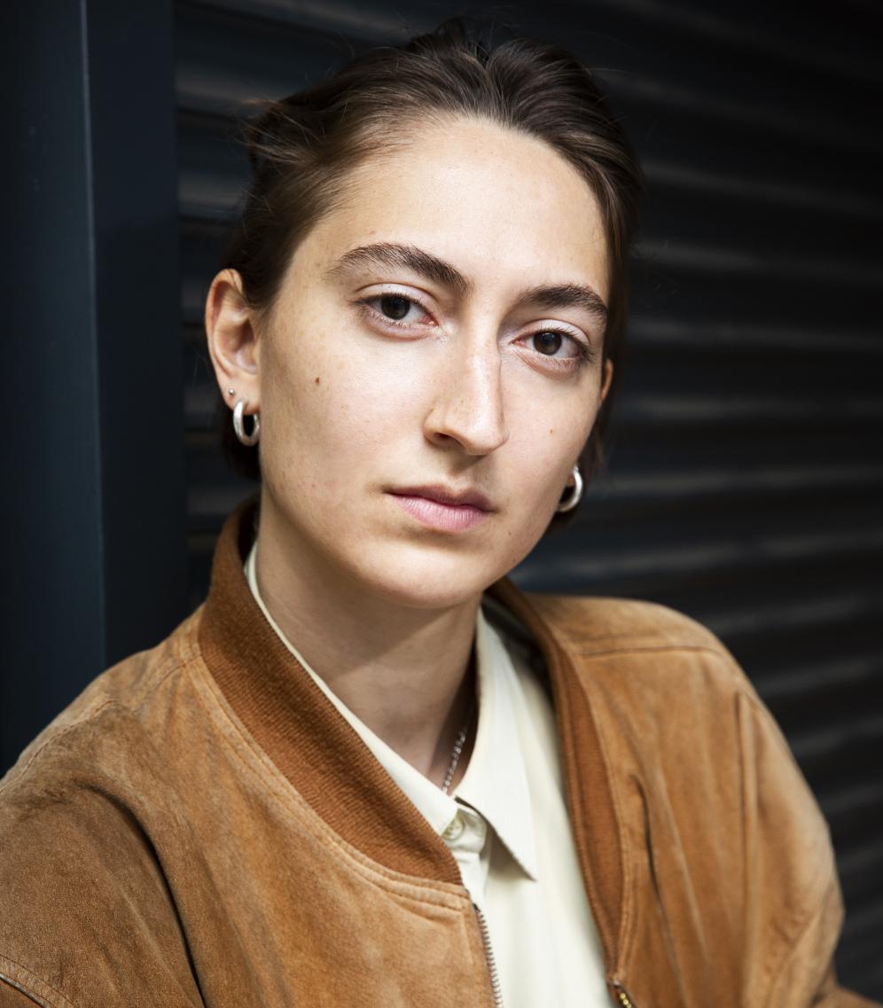 Vanessa Bärtsch Portrait der Studierenden in brauner Jacke, frontal.