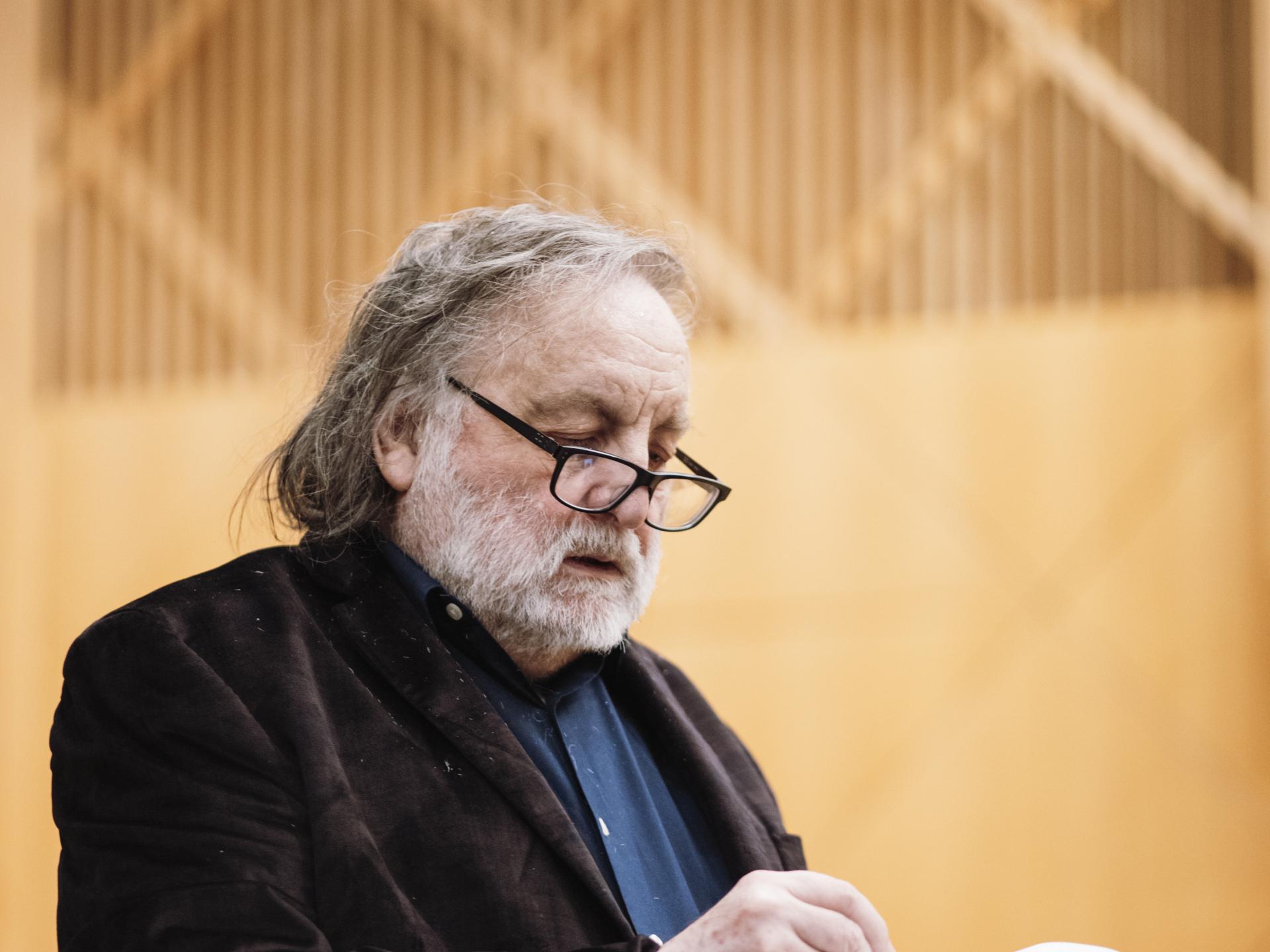 Brian Ferneyhough notiert etwas auf einem Notenblatt