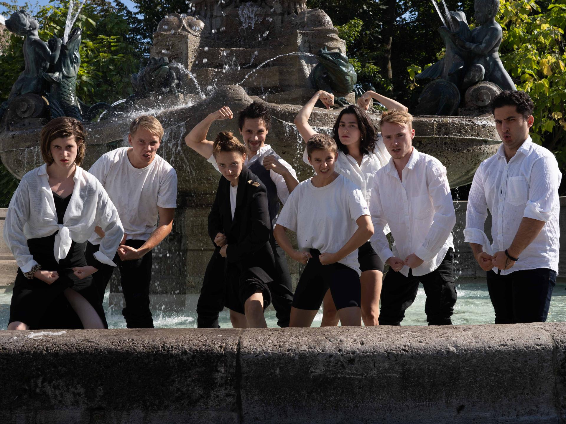 Gruppenfoto im Brunnen, alle machen eine kämpferische Pose.