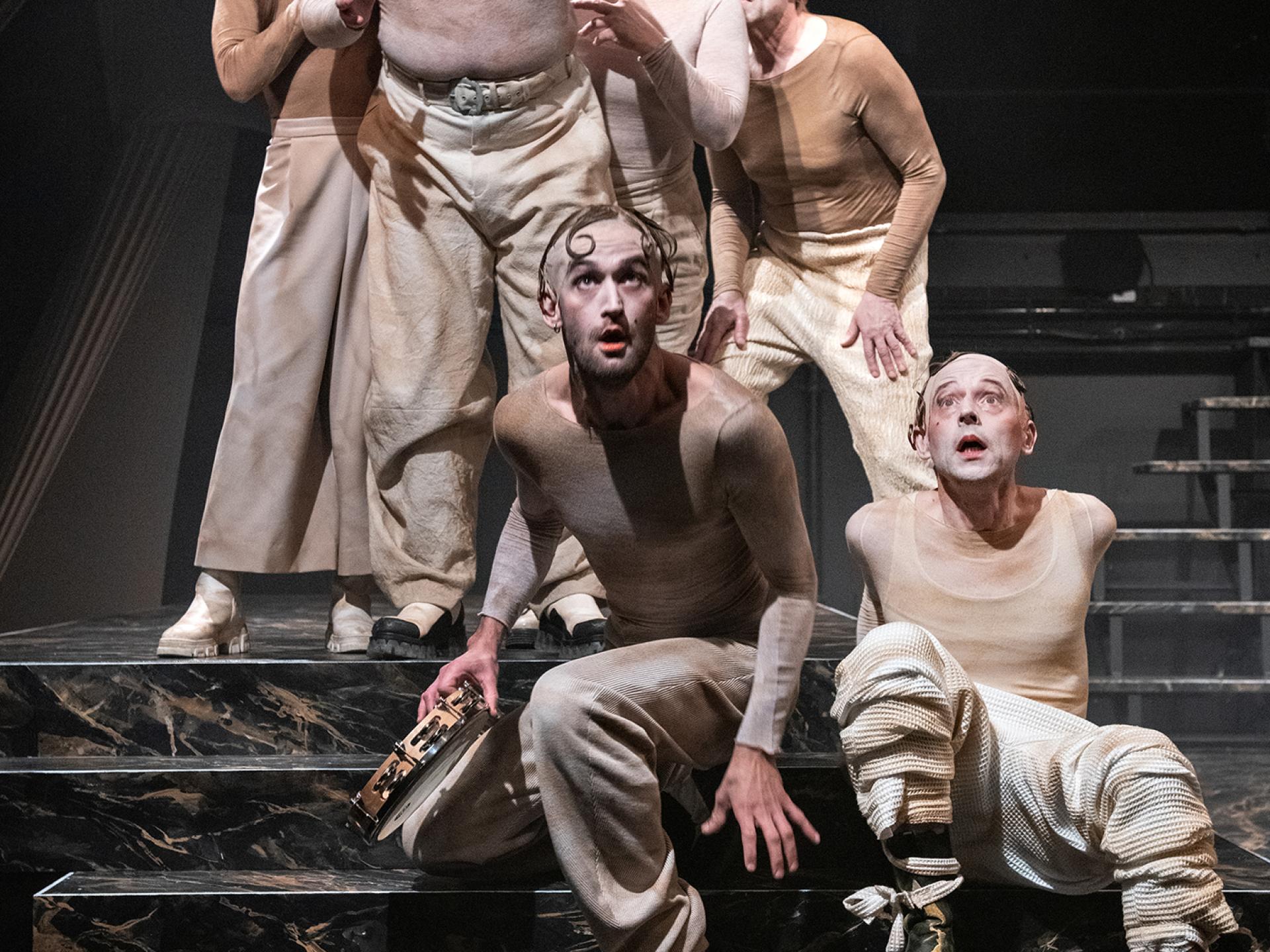 Das Ensemble sitzt auf der Bühne auf einer Treppe in der Inszenierung von "Tyll" am Theater Heidelberg im Dezember 2021.