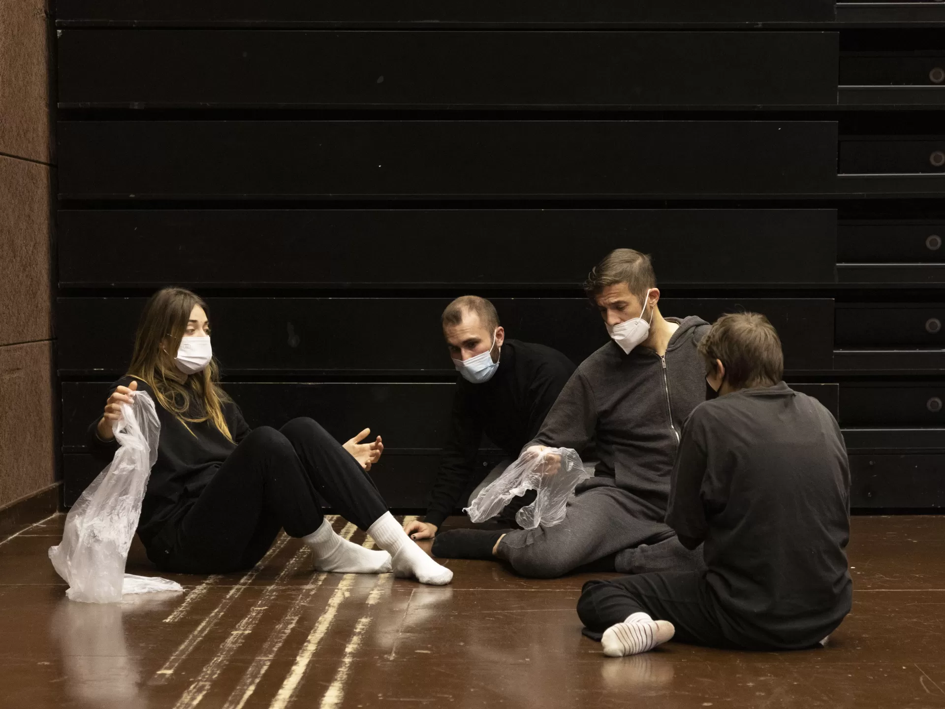 Vier Studierende sitzen auf dem Boden und proben für das Projekt Agua.