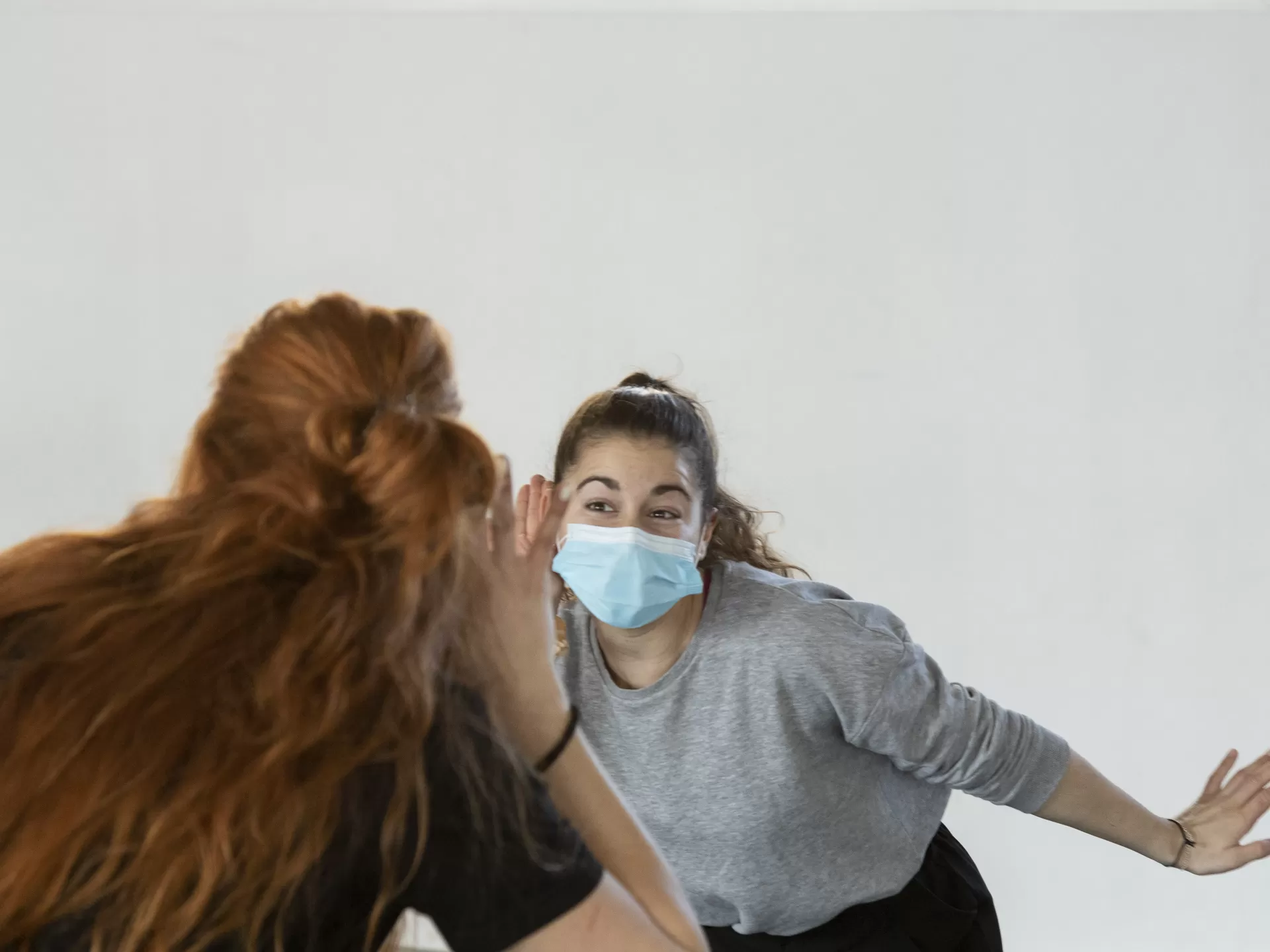 Eine Darstellerin, Hand ans Ohr gelegt, wie um besser zu hören.