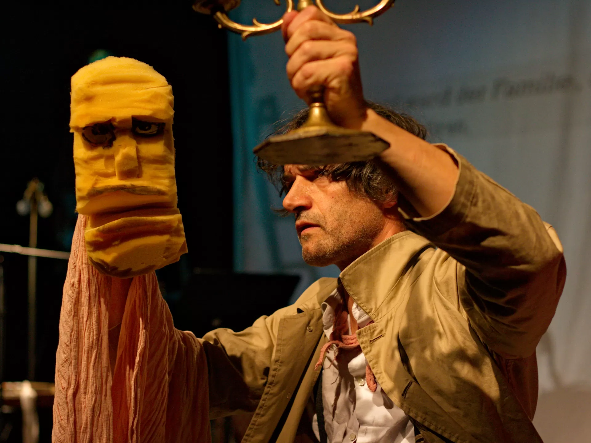 Ein Mann ist seitlich zu sehen und hat eine Handpuppe aus Schaumstoff auf der rechten Hand.