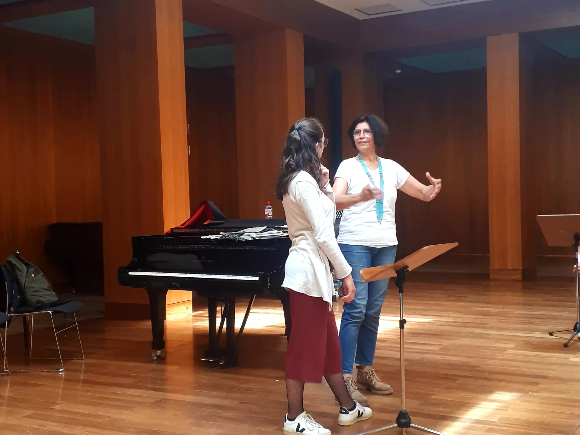 Frau Vallesi und eine Studentin stehen am Dirigierpult, Vallesi zeigt etwas