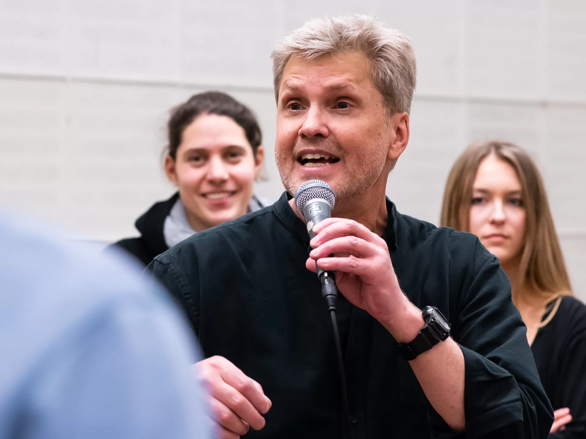 Roger Treece in einem Workshop, in der linken Hand hält er ein Mikrofon.