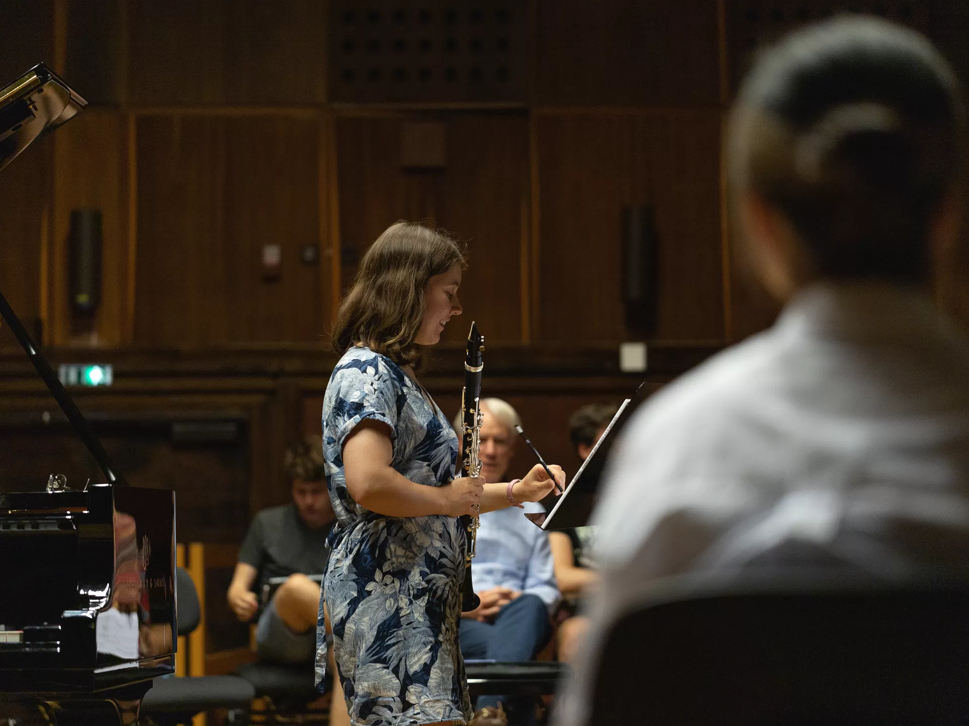 Klarinettistin, die sich mit einem Bleistift eine Notiz zu den Noten macht.