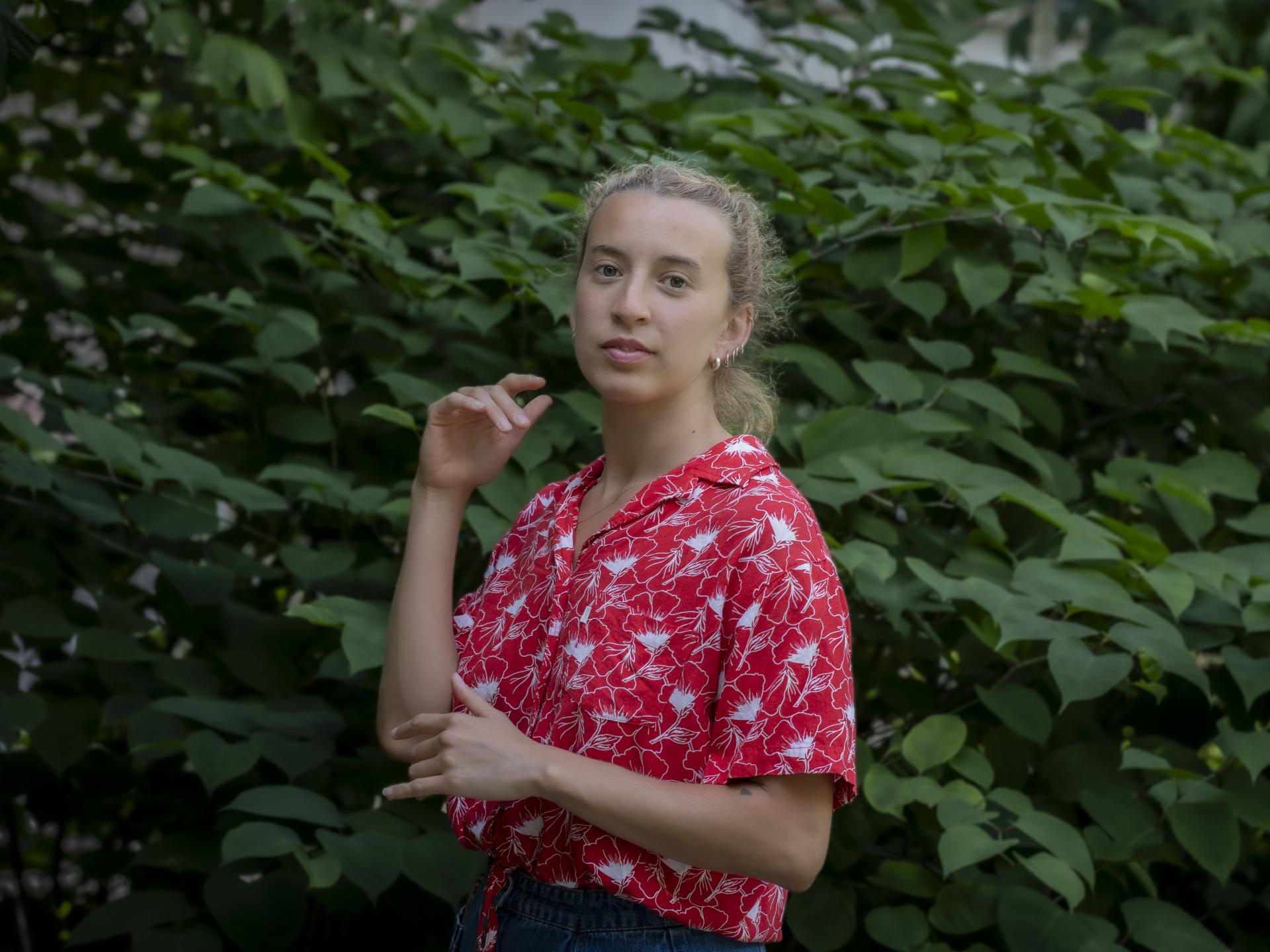 Ein Portrait der Studierenden Laura Ahumada vor einem Gebüsch.