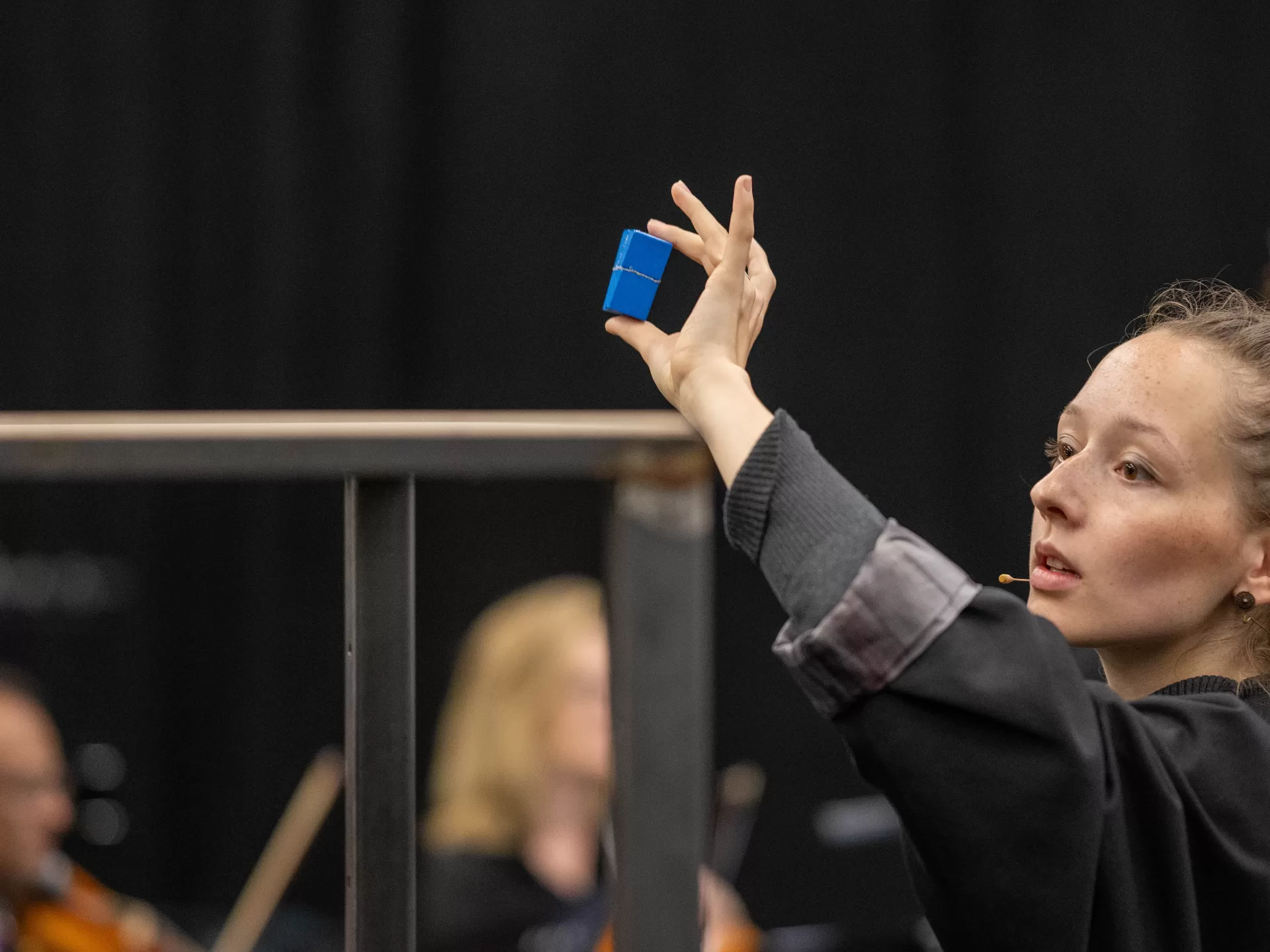 Schauspielerin hält in einer Szene ein kleines blaues Kästchen hoch
