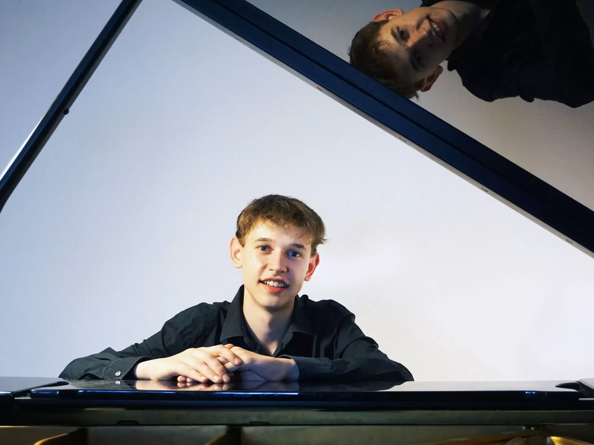 Porträt von Kolja Hölscher sitzend am geöffneten Flügel