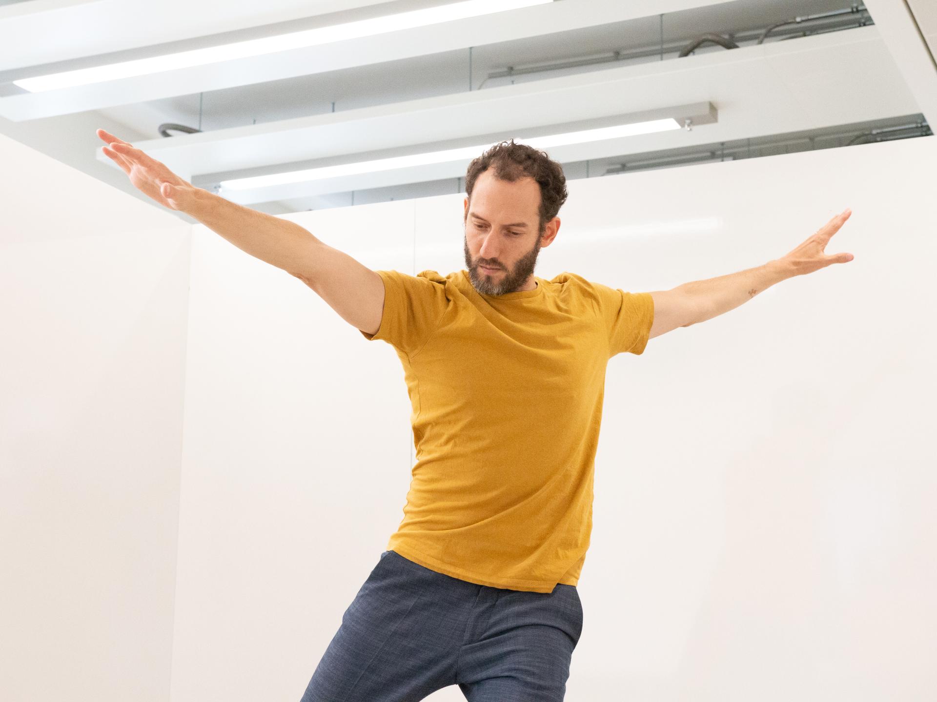 Man in yellow shirt making a pose