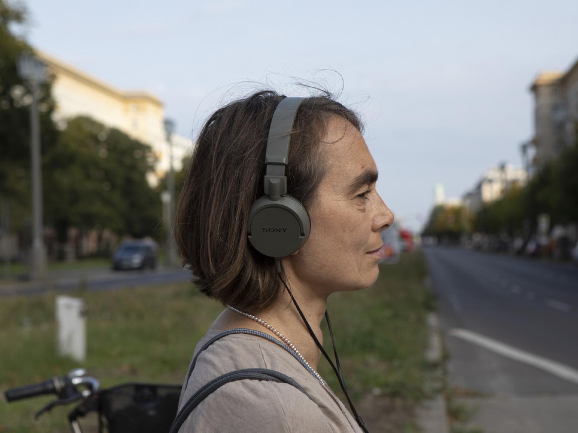Frau mit Kopfhören im Profil