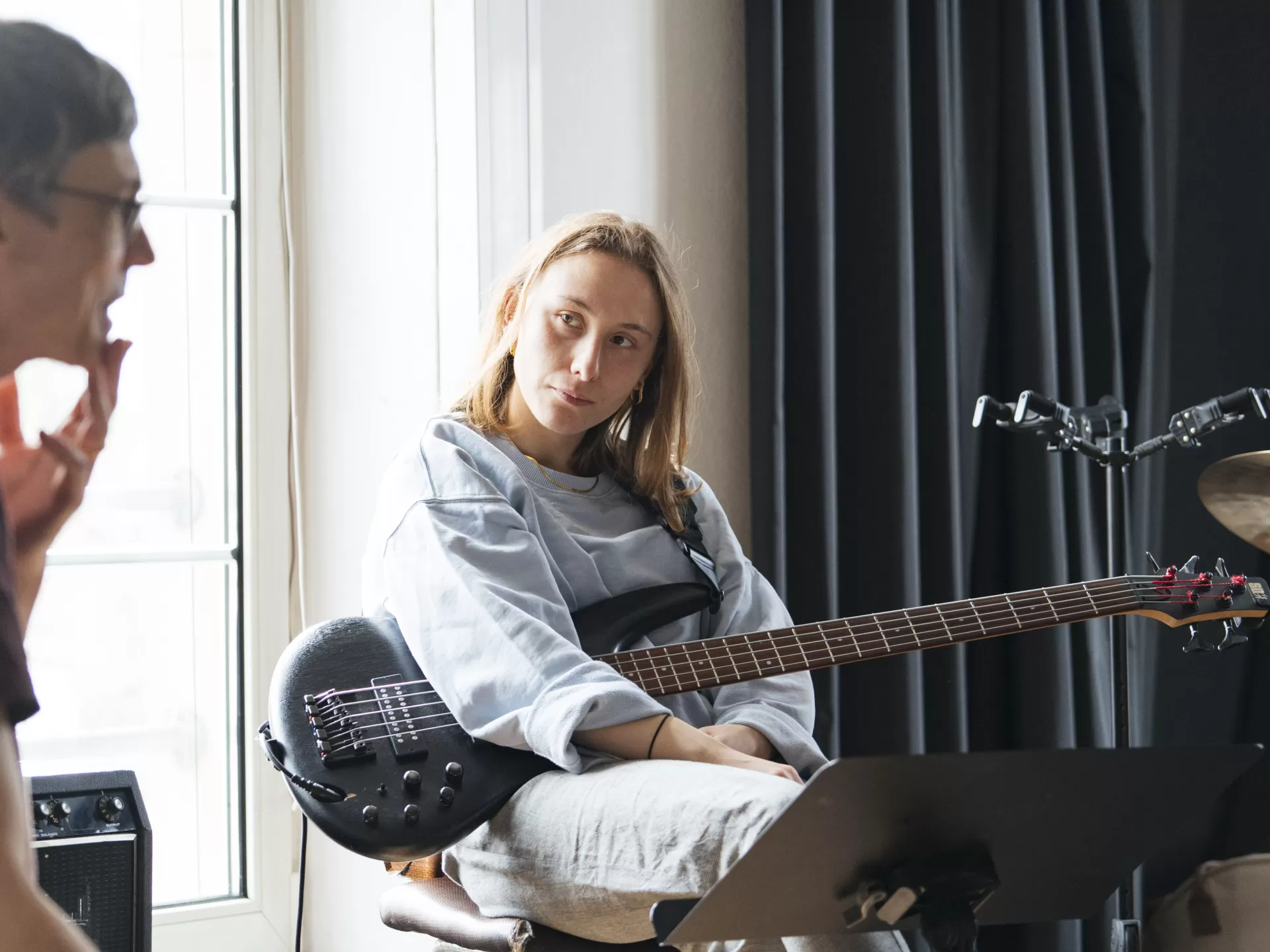 Die Bassistin hört dem Coach zu.
