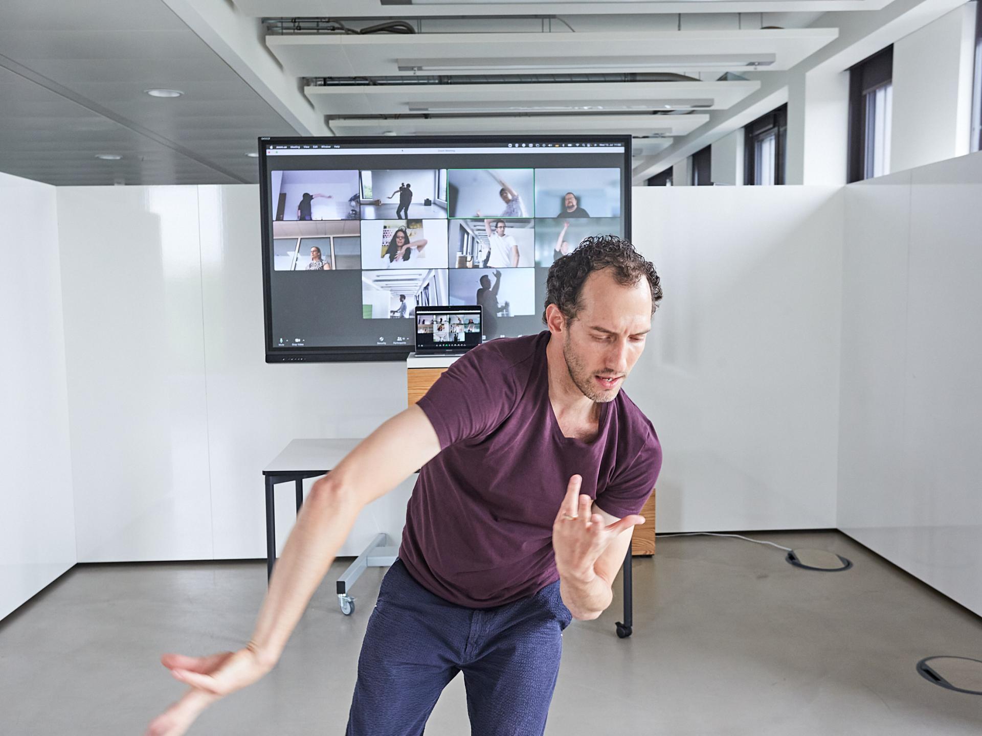 man dancing in front of a screen