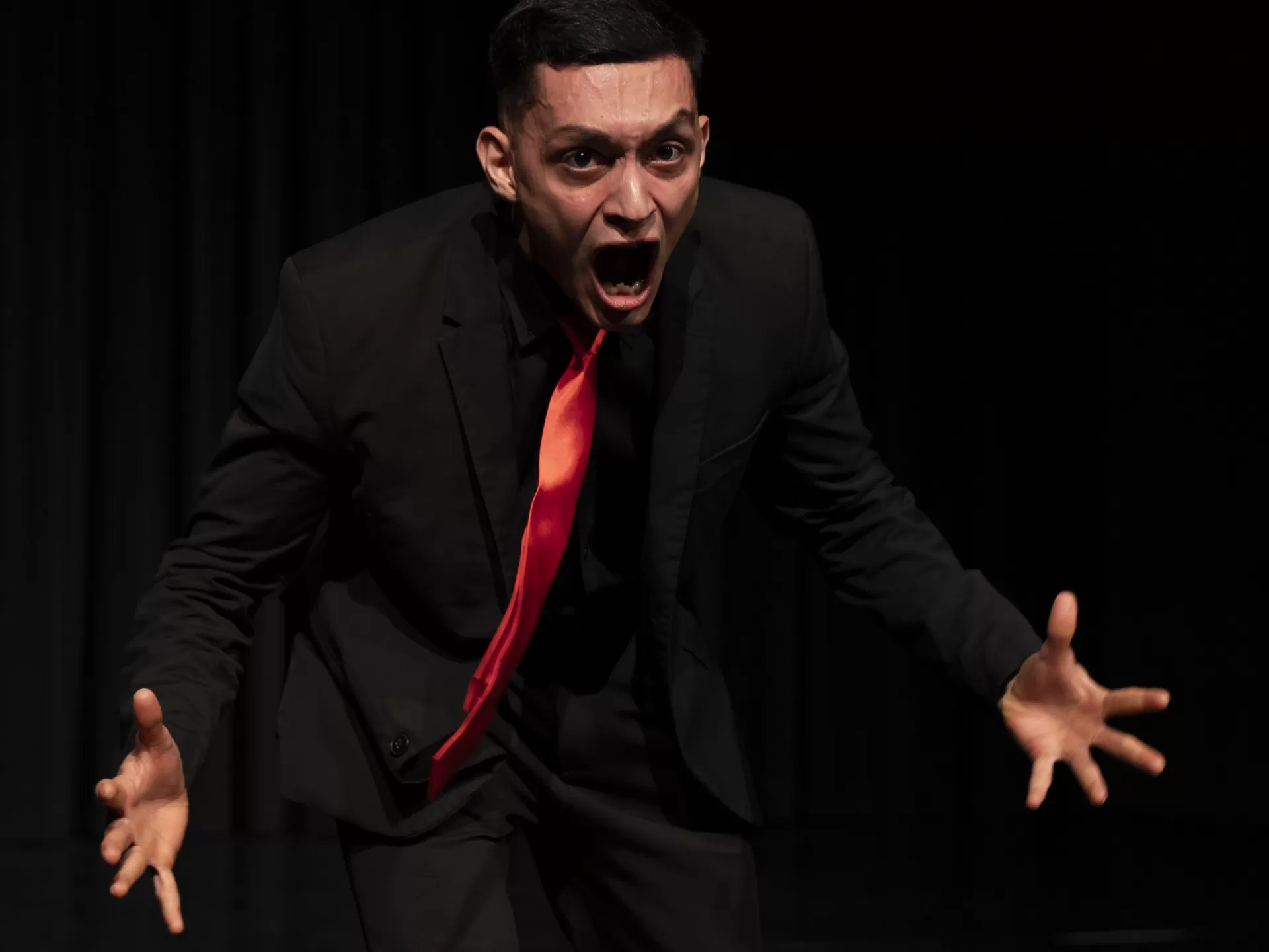 Ein Mann im schwarzen Anzug schreit.