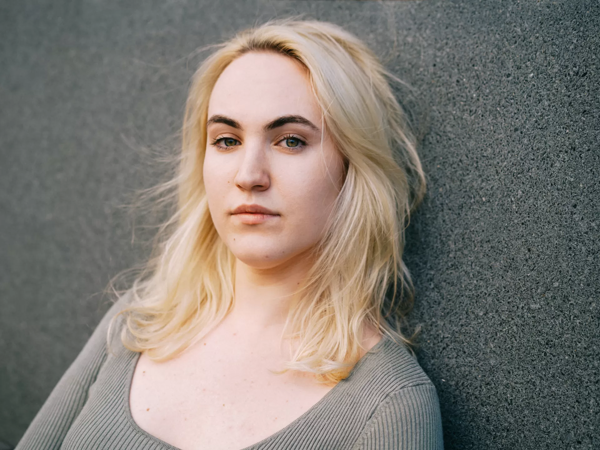 Eine Frau mit blonden Haaren lehnte an der Wand