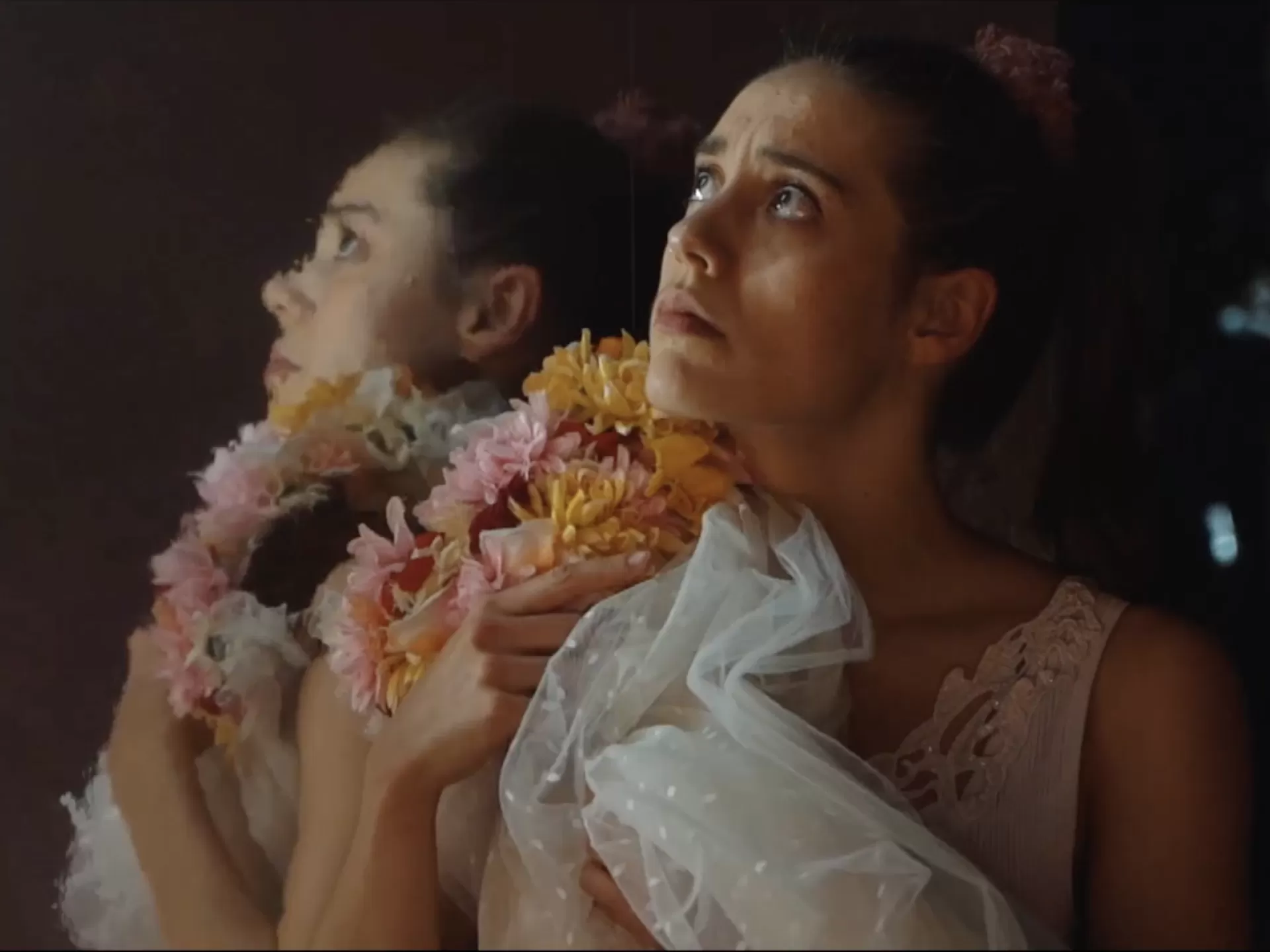 Frau, die einen Blumenkranz und Schleier an sich drückt.