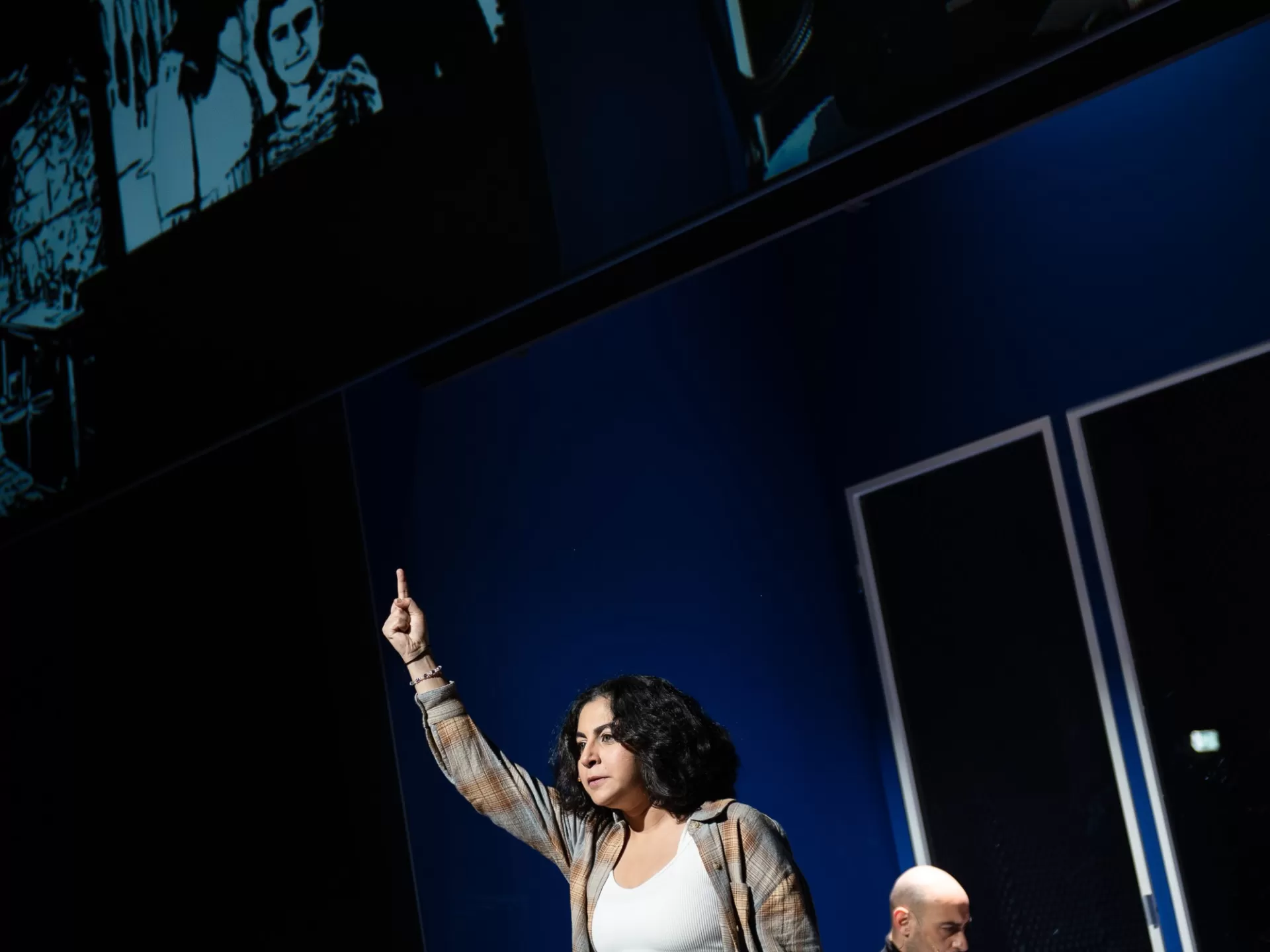 Frau im Vordergrund stehend, die den Arm nach oben streckt.