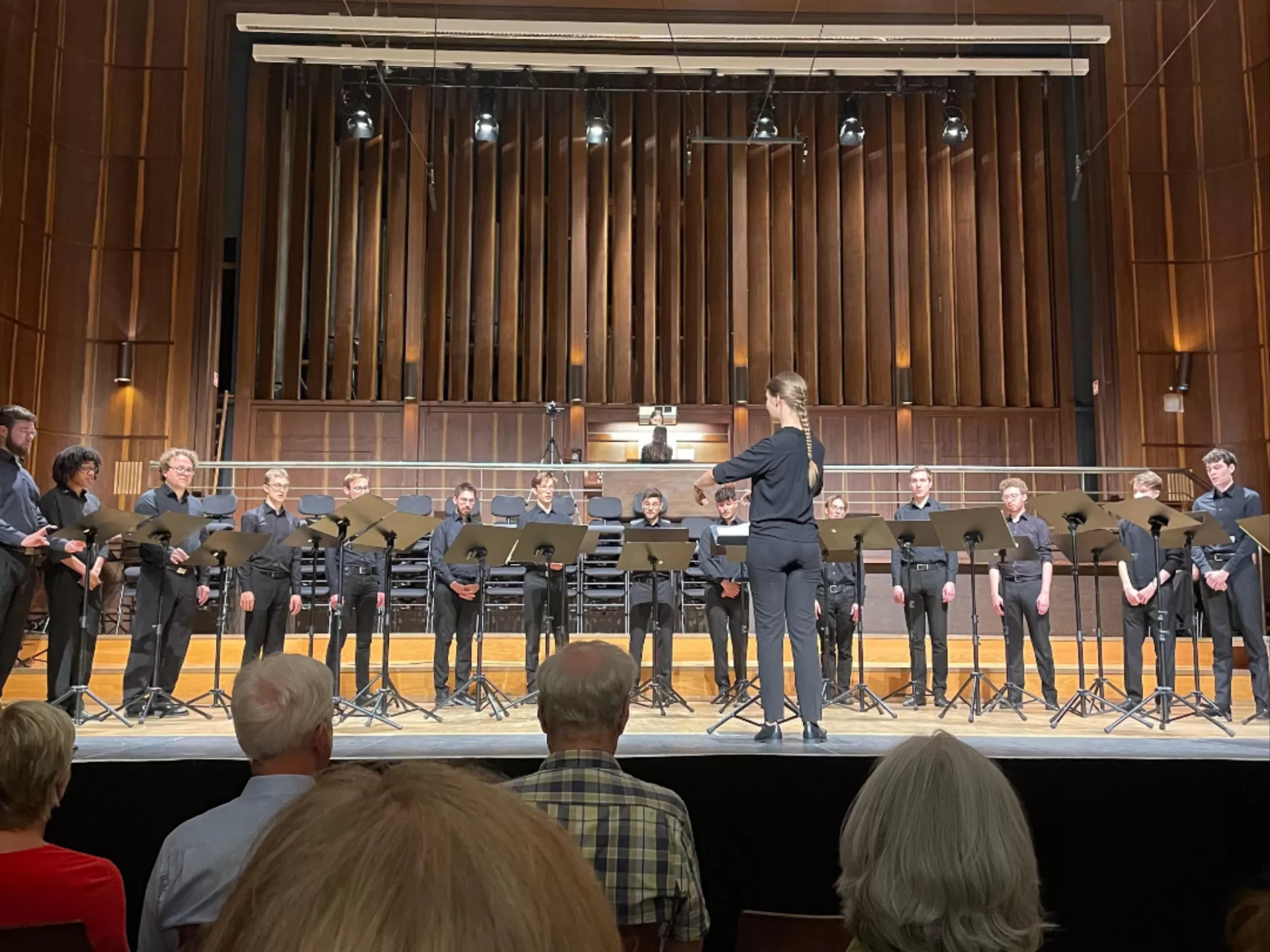 Männerchor singt, Studentin dirigiert