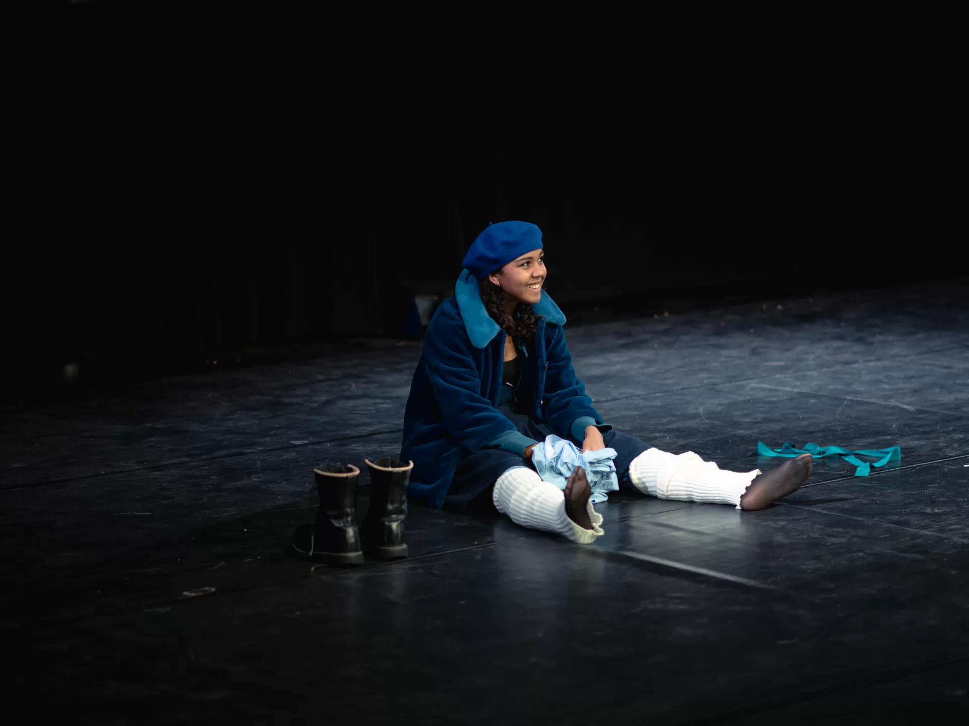 Junge Frau in blauer Kleidung sitzt auf dem Boden.