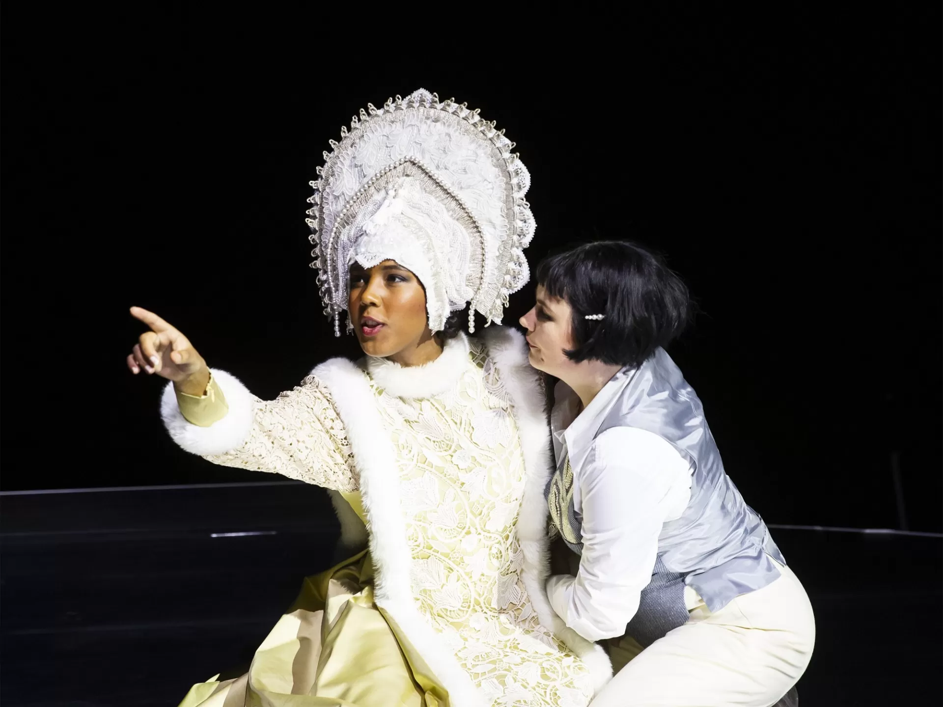 Frau ist edlem Kostüm zeigt nach vorne.