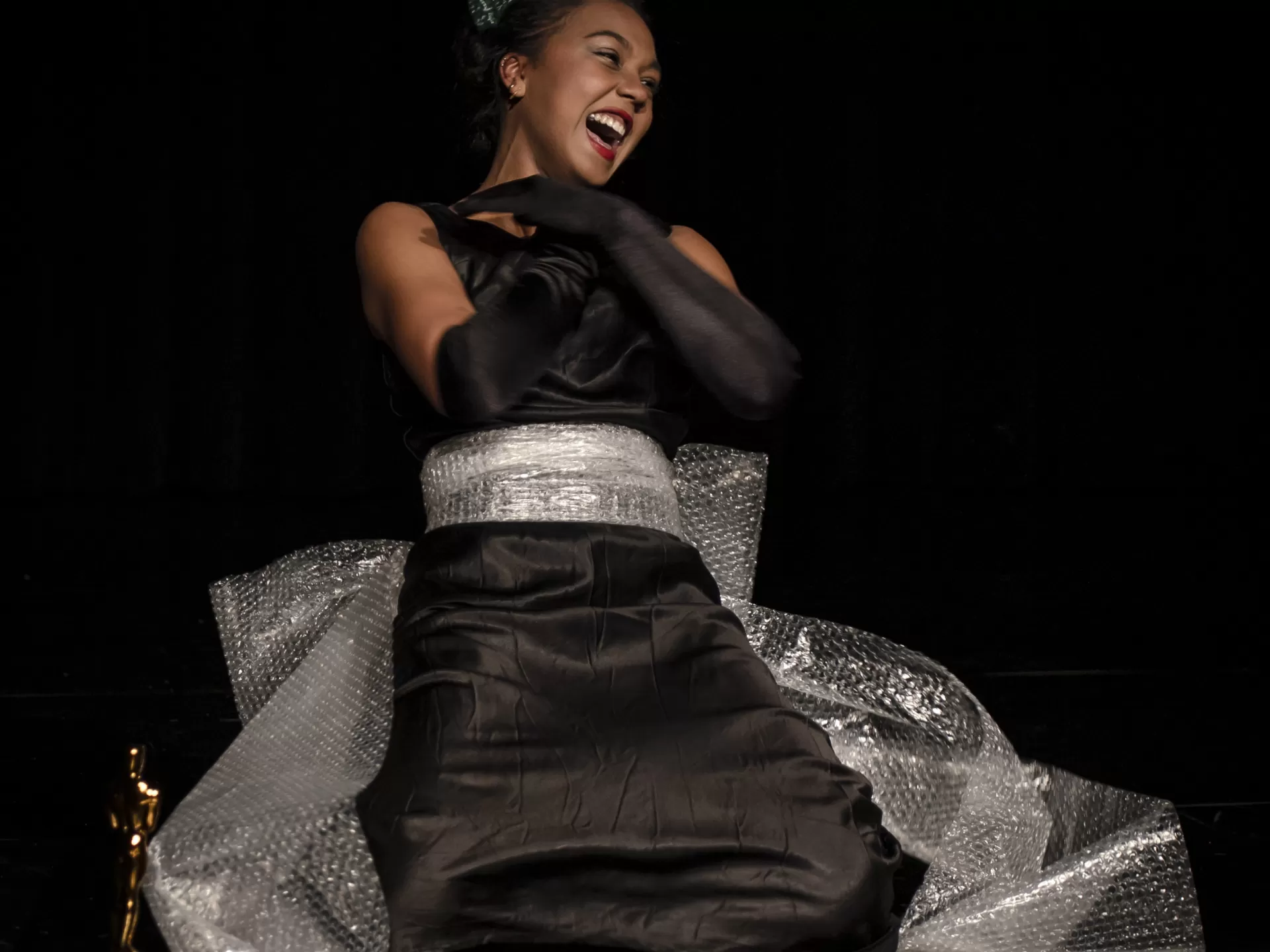 Frau sitzt auf dem Boden und lacht.