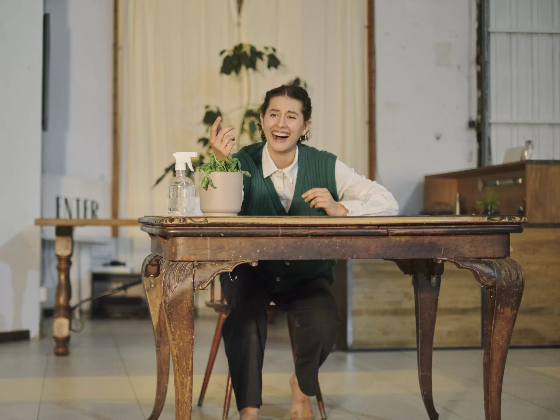 performance, woman at a table watering a plant