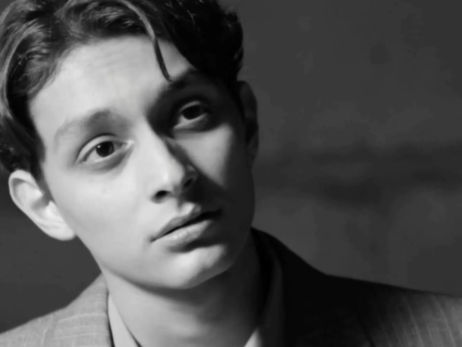 Schwarz-weiß-Portrait eines Mannes im Anzug.