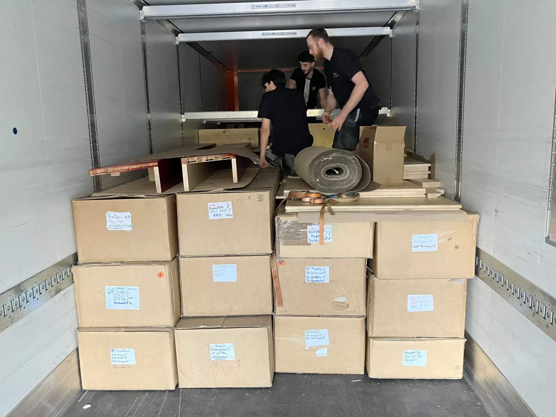 Die Handwerker*innen verstauen die Einzelteile der Orgel im LWK. Man sieht Kartons und Holzteile.