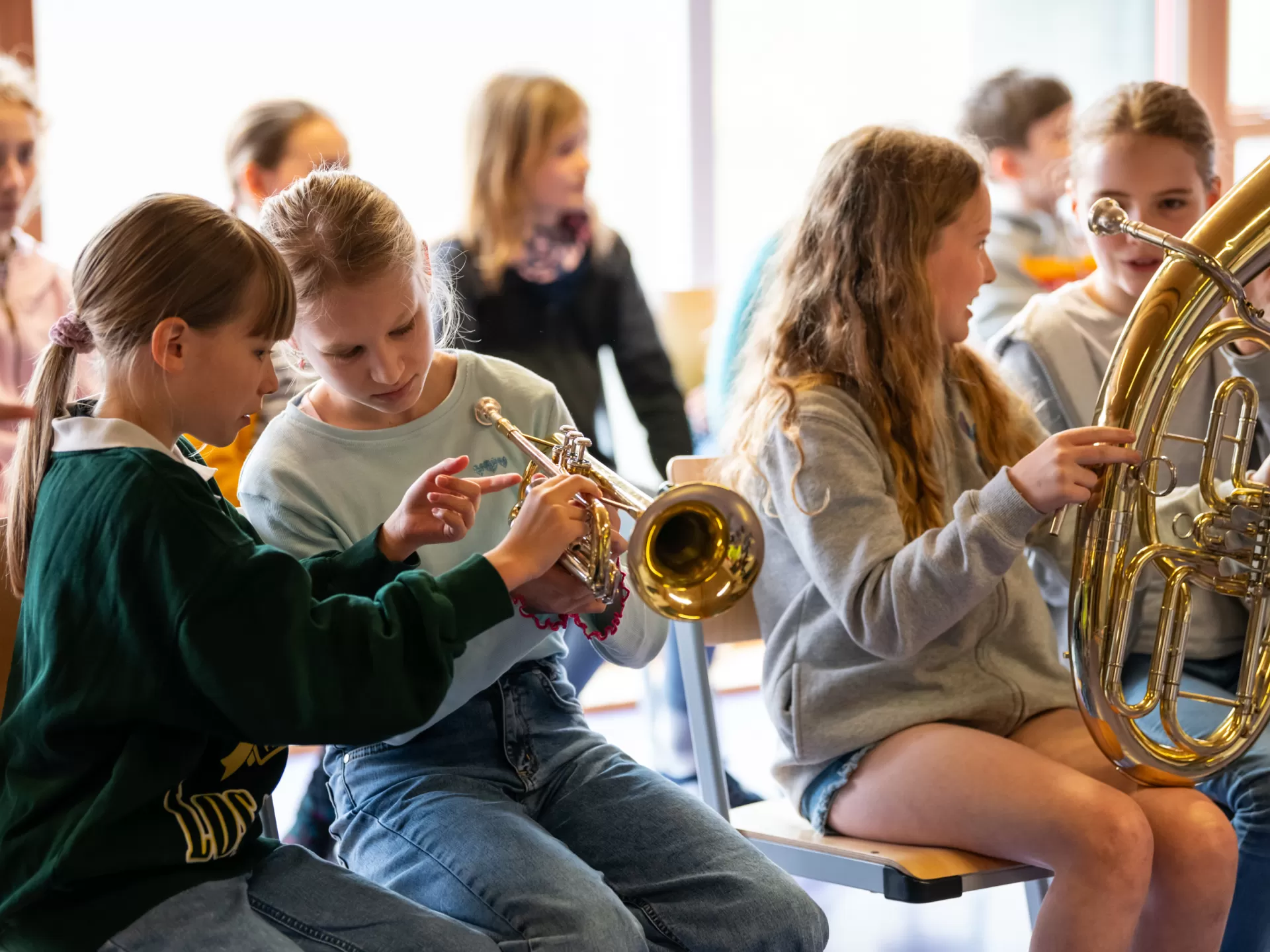 Zwei Schülerinnen schauen sich eine Trompete genauer an