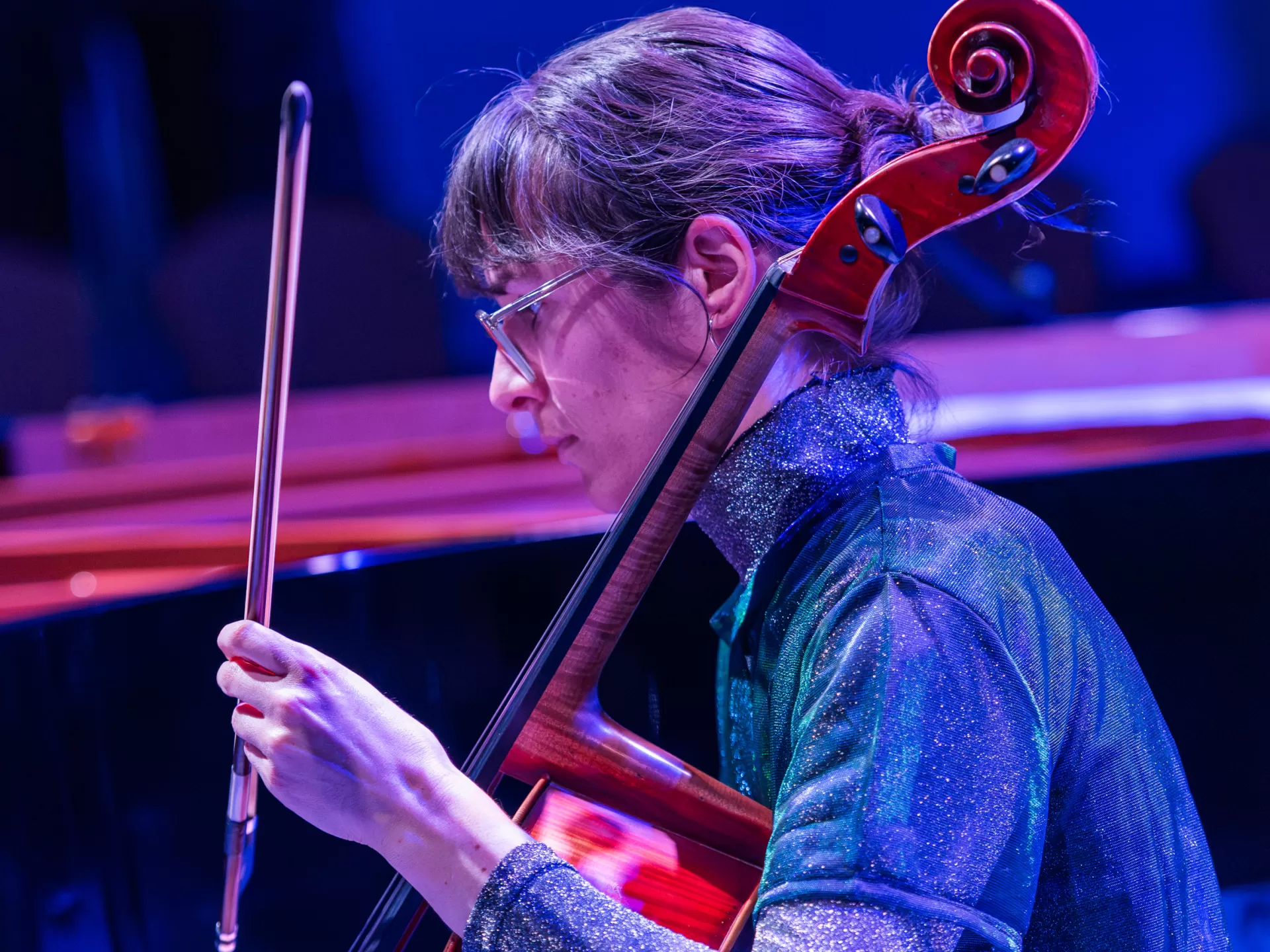 Die Cellistin spielt, umgeben von blauem Licht.