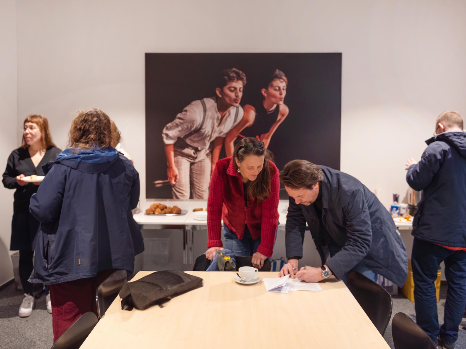 In der Forschung wird an der HfMDK nicht nur innerhalb der einzelnen Fächer, sondern auch interdisziplinär diskutiert. Eine Gruppe von Personen diskutiert vor einem Buffet in unterschiedlicher Zusammensetzung.