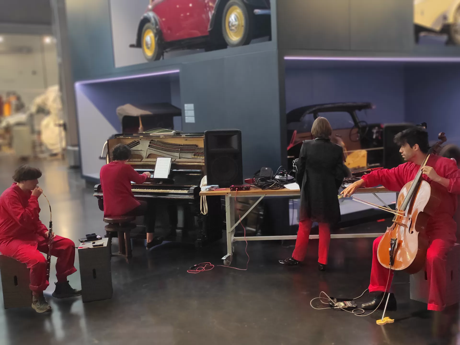 Vier rot-schwarz gekleidete Menschen musizieren im Industriemuseum