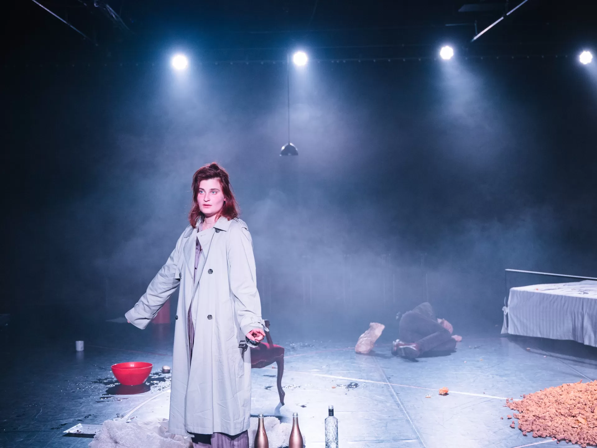 Frau in Mantel steht im Nebel.