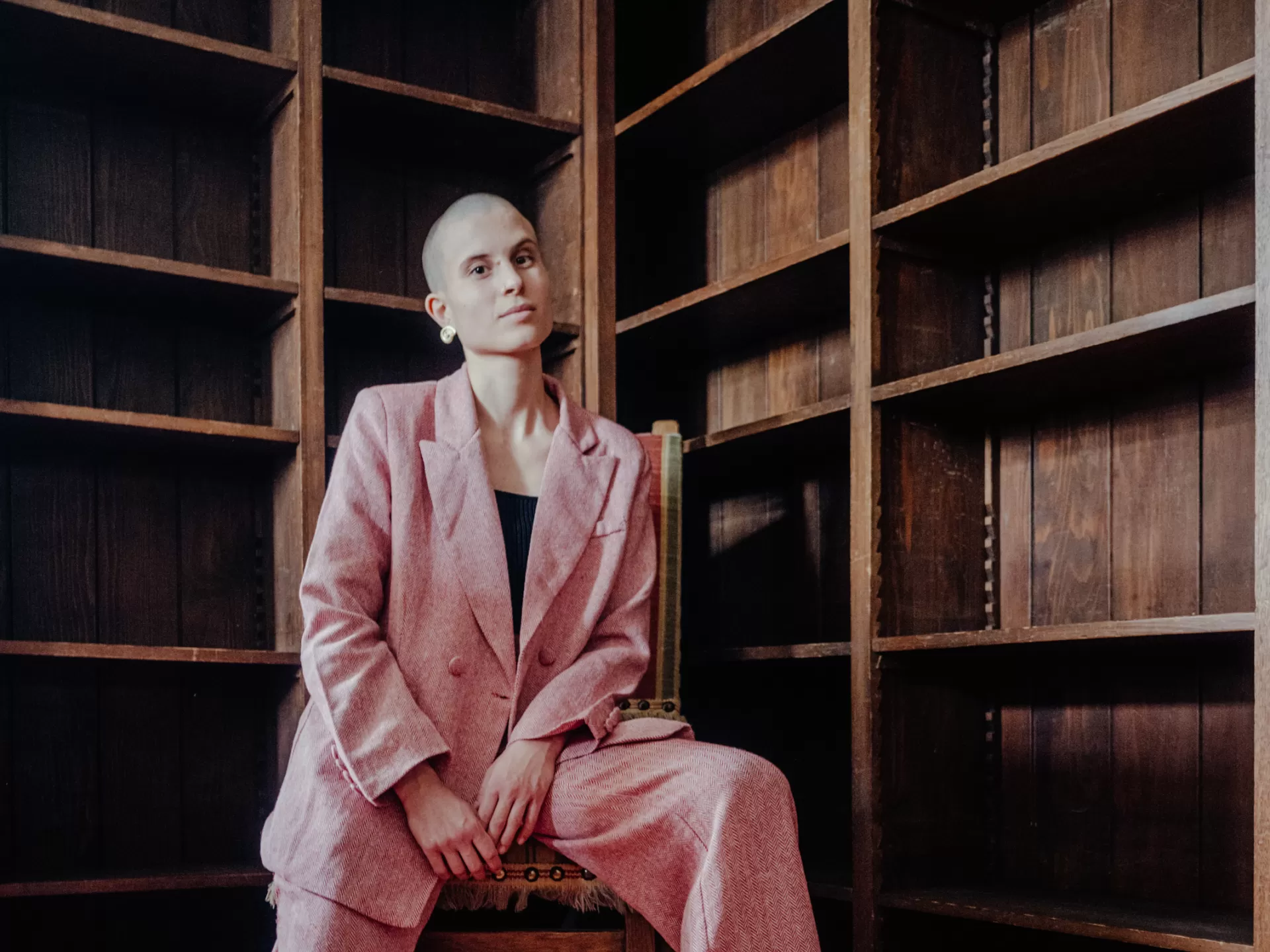 Lisa Freiberger sitzt auf einem Stuhl, sie trägt einen roten Anzug.