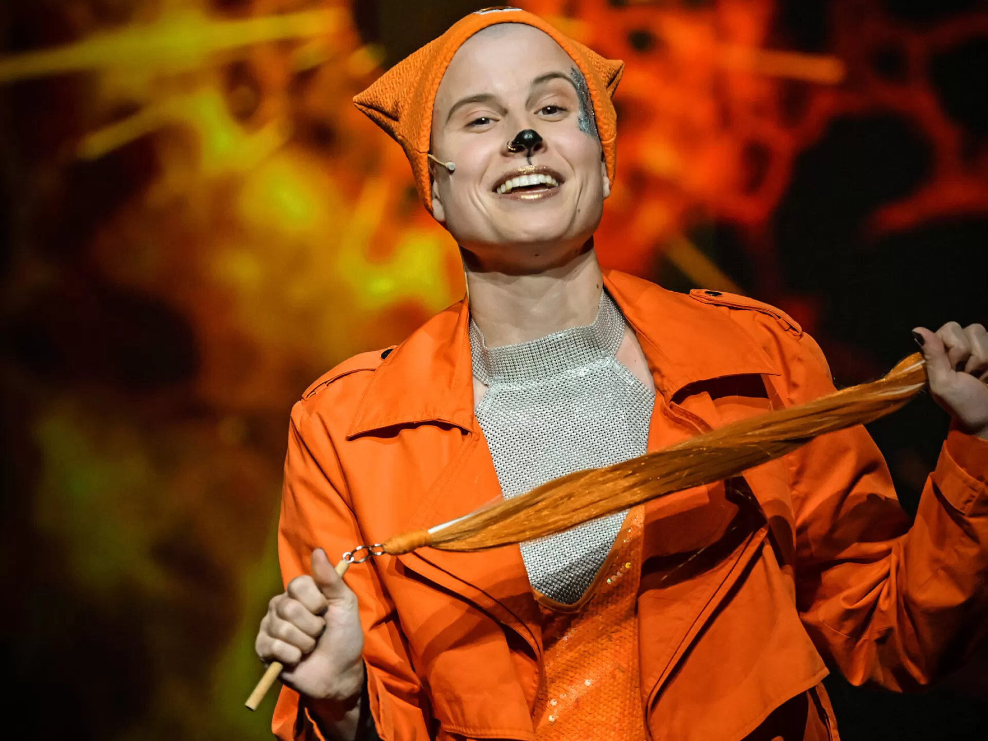 Lisa hält einen Fuchsschwanz in der Hand und lacht in die Kamera.