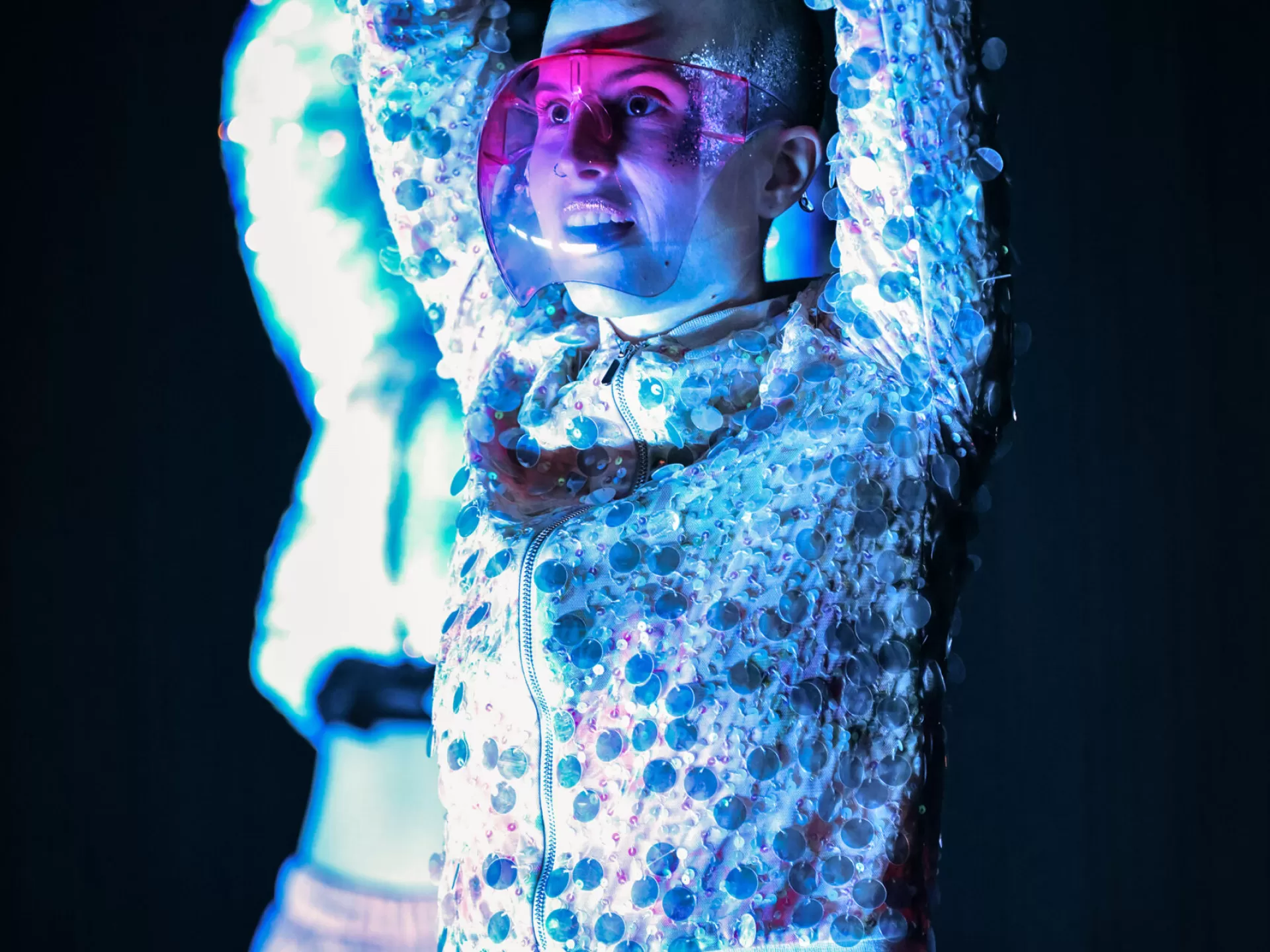 Lisa hat die Hände über dem Kopf zusammengeschlagen und blickt schräg nach vorne. Sie trägt ein Visier.