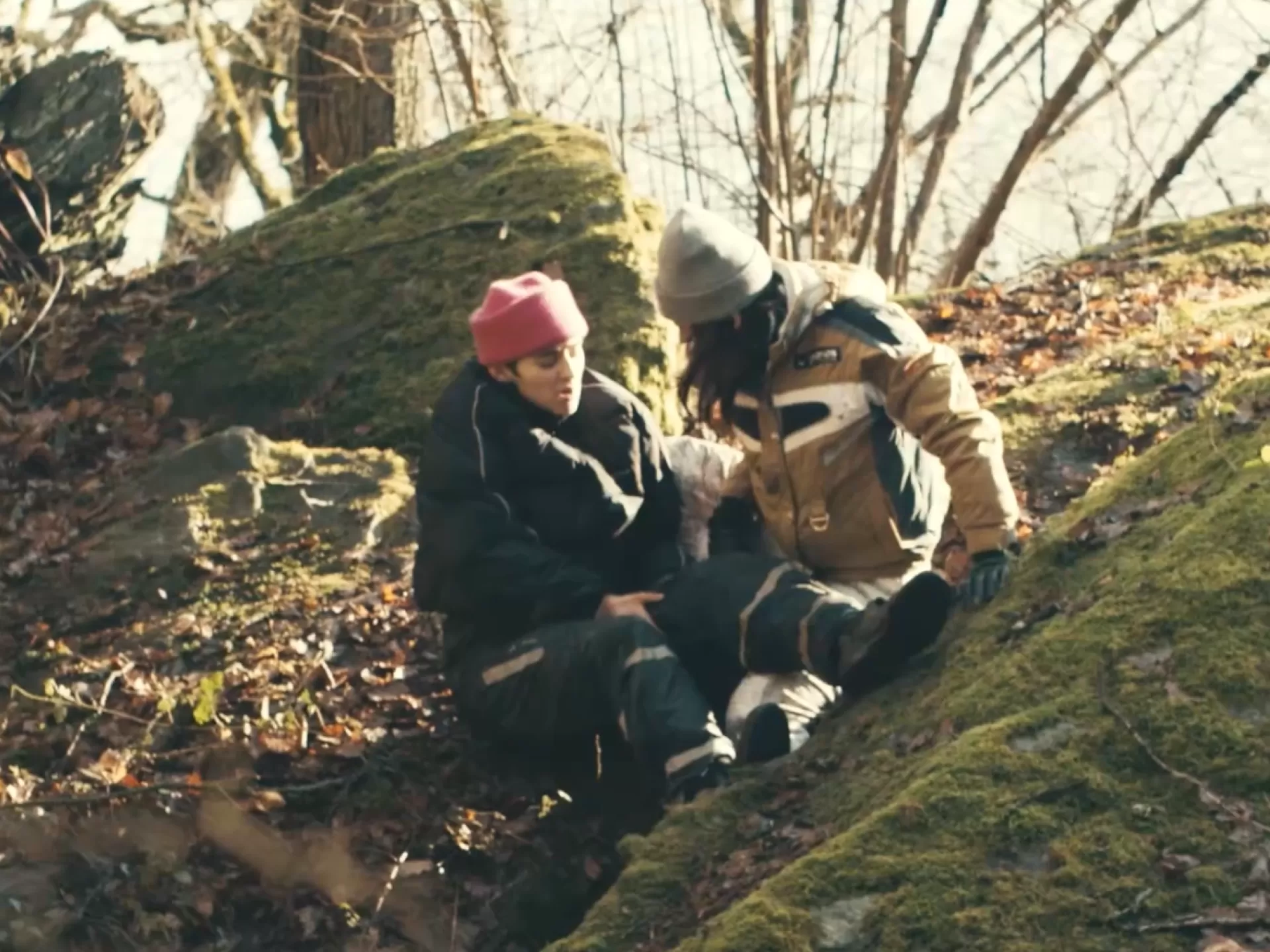 Zwei junge Frauen, die eine verletzt, im Wald.