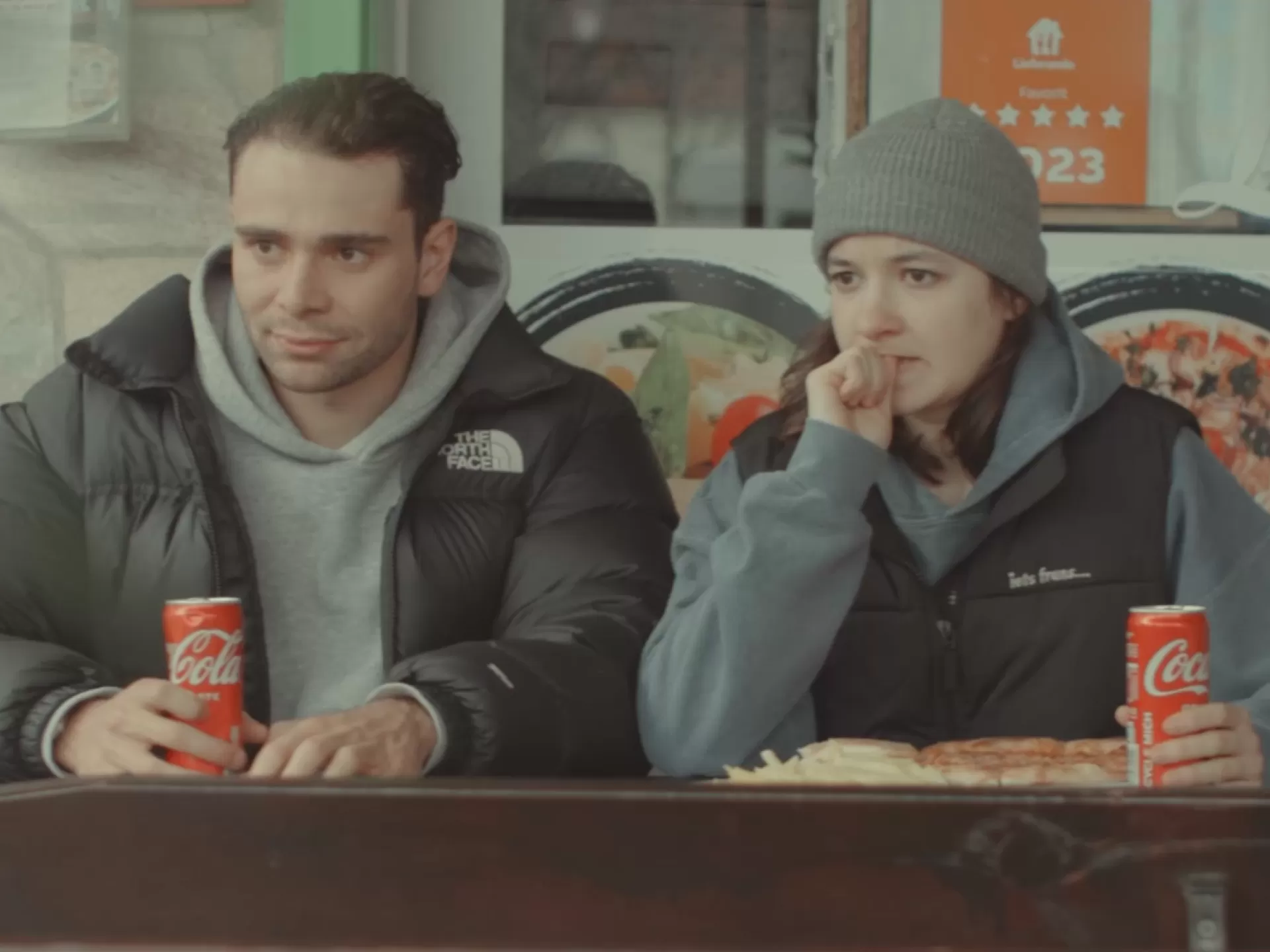 Zwei Personen auf der Terrasse einer Pizzaria.