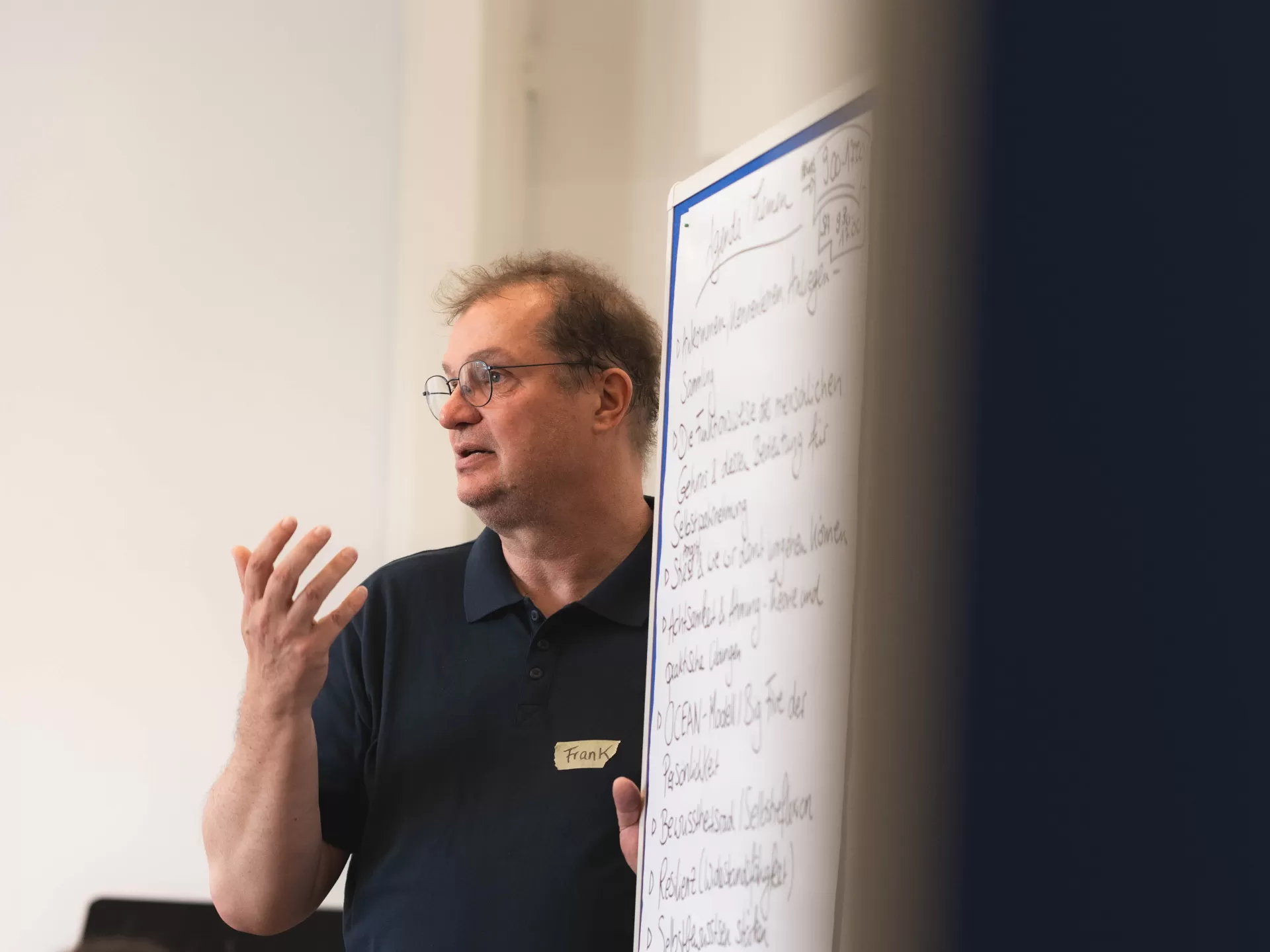 Ein Mann steht neben einer Flipchart und trägt etwas vor.