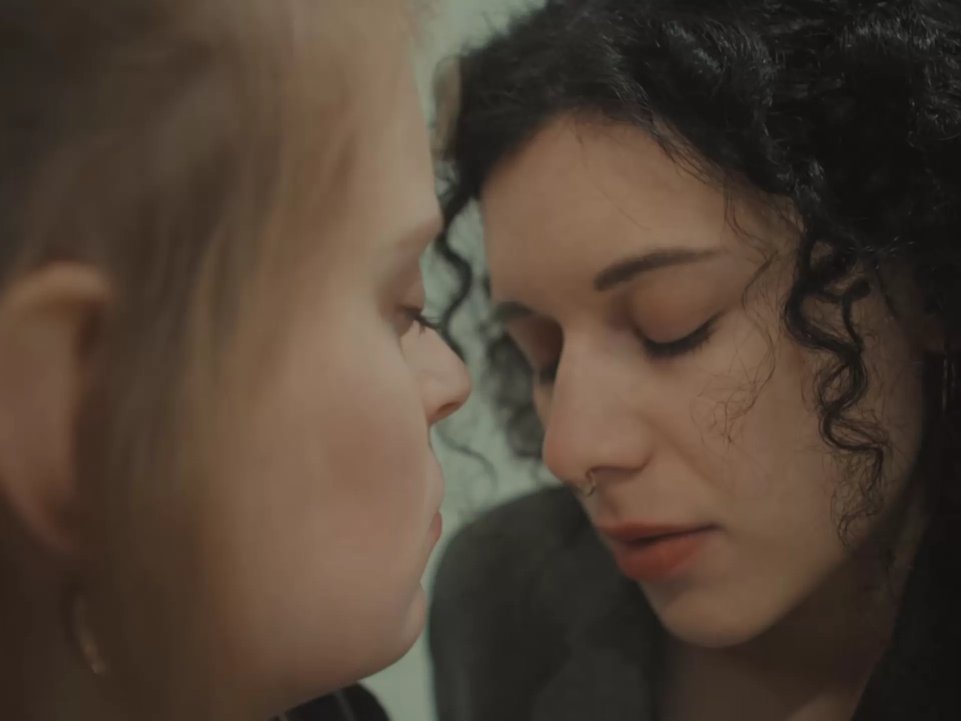 Zwei junge Frauen in einer Nahaufnahme, die Augen geschlossen.