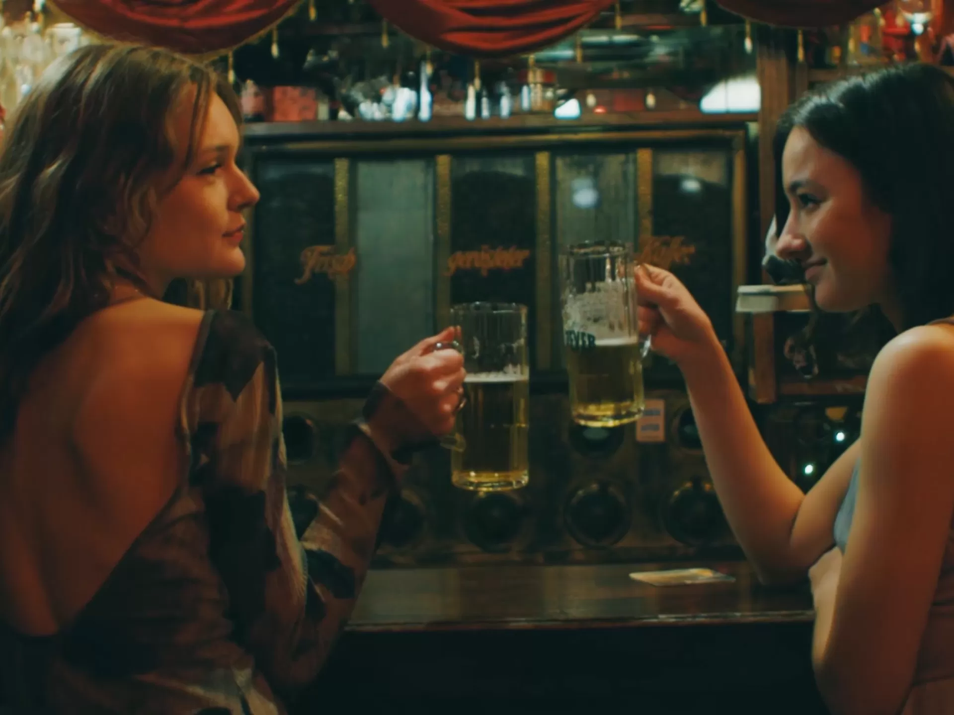 Zwei Frauen sitzen an einer Bar in einer Kneipe.