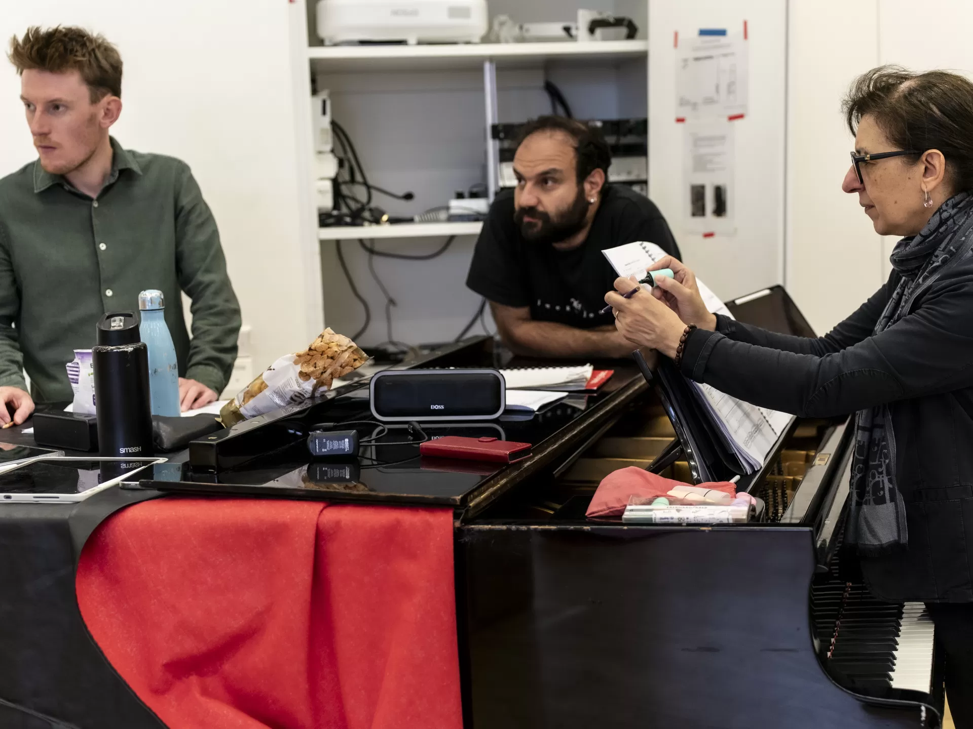 Drei Menschen stehen um einen Flügel herum