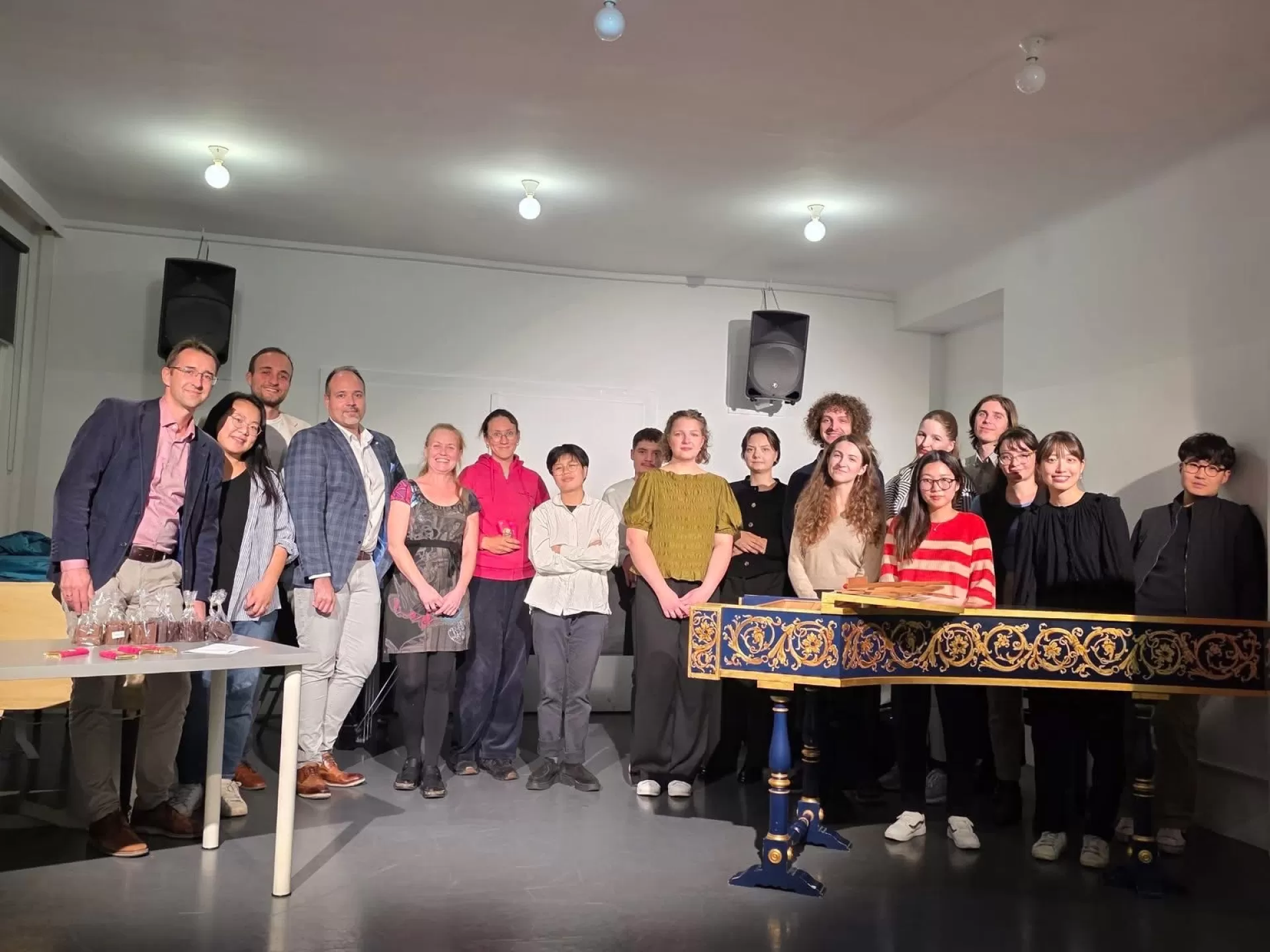 Eine Gruppe Menschen steht versammelt hinter einem Cembalo.