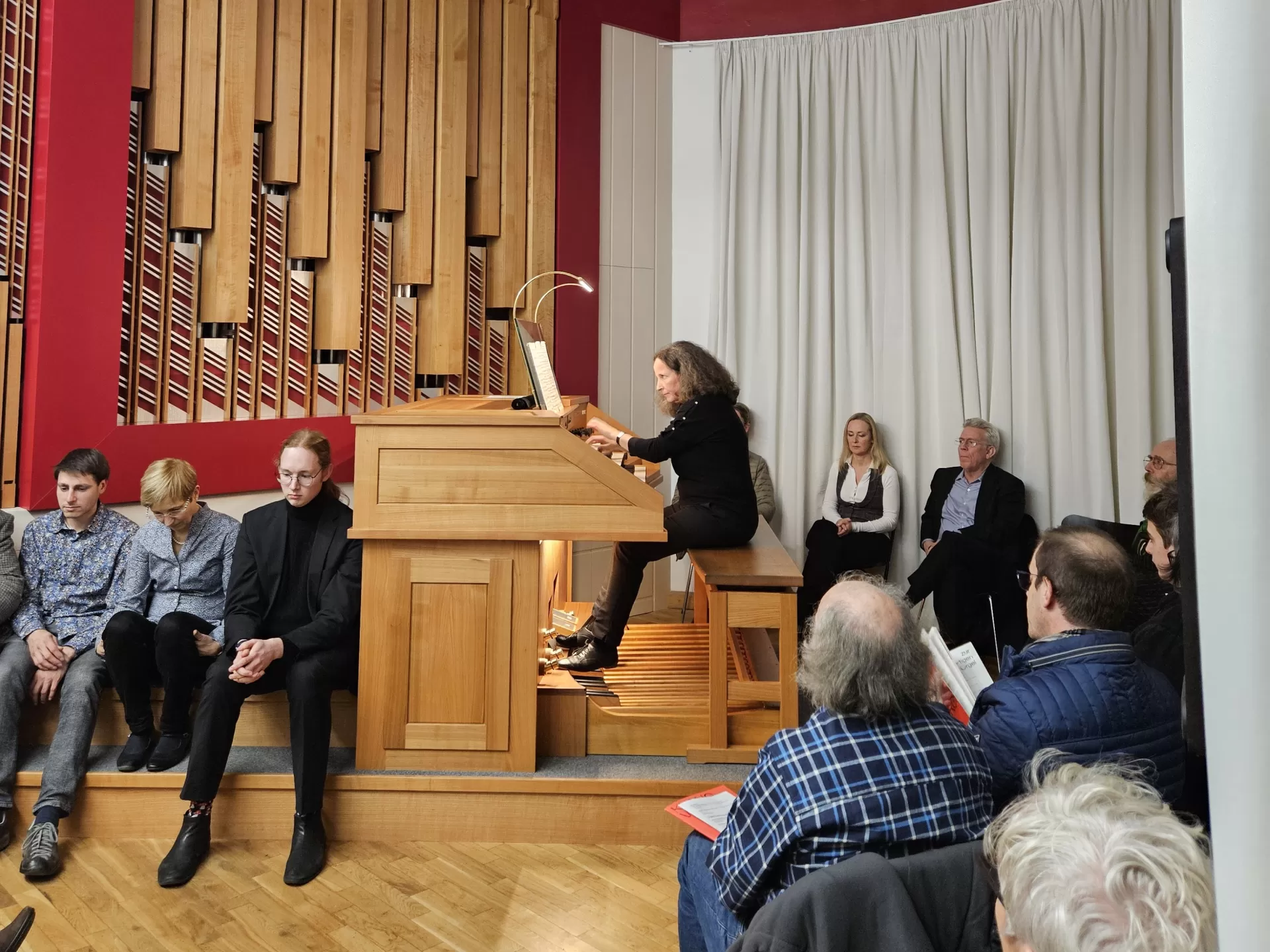 Kirsten Sturm spielt an der Orgel, der Raum voller Zuhörenden