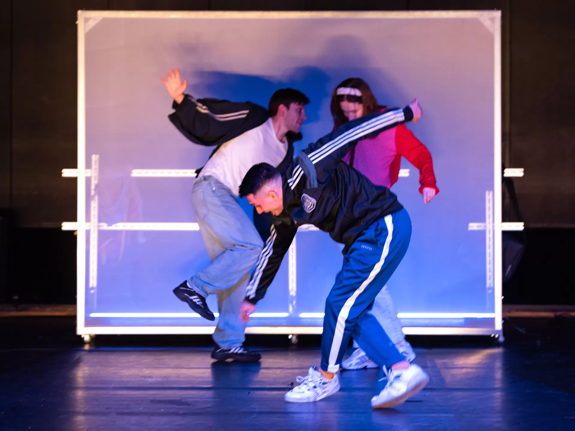 Drei Personen vor einer Stellwand.