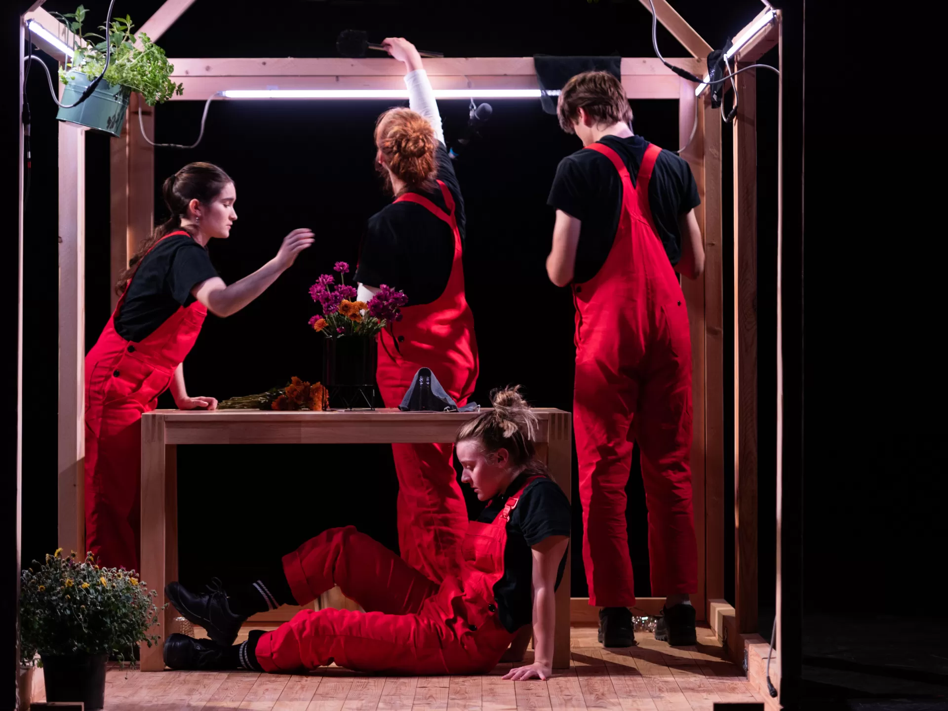 Vier Personen in roten Latzhosen.