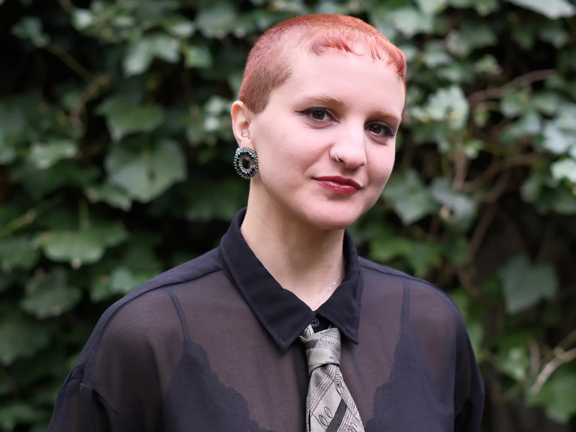 Portrait der MA CoDE_Studierenden Giada Grieco vor einem Hintergrund mit Blättern.