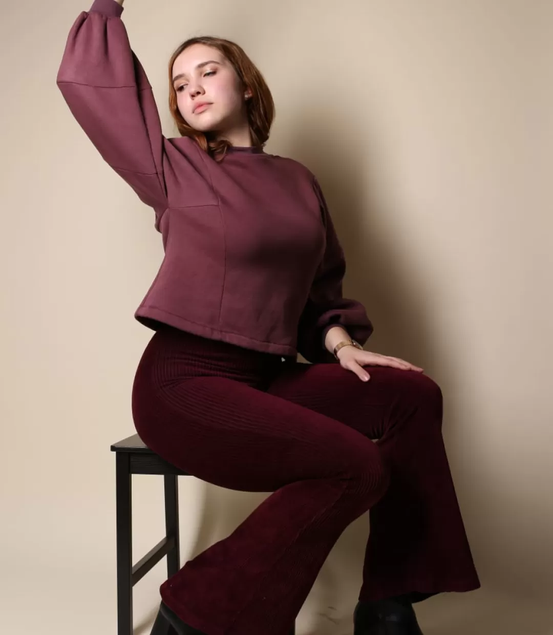 Anna Turowez. Auf einem Stuhl sitzend. Ein Arm schwingend.