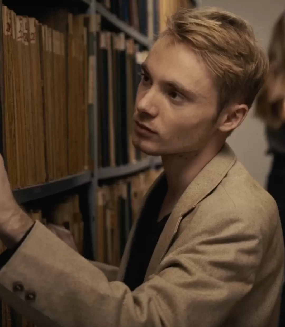 Ein Mann und eine Frau suchen nach einem Buch in den Regalen einer Bibliothek.